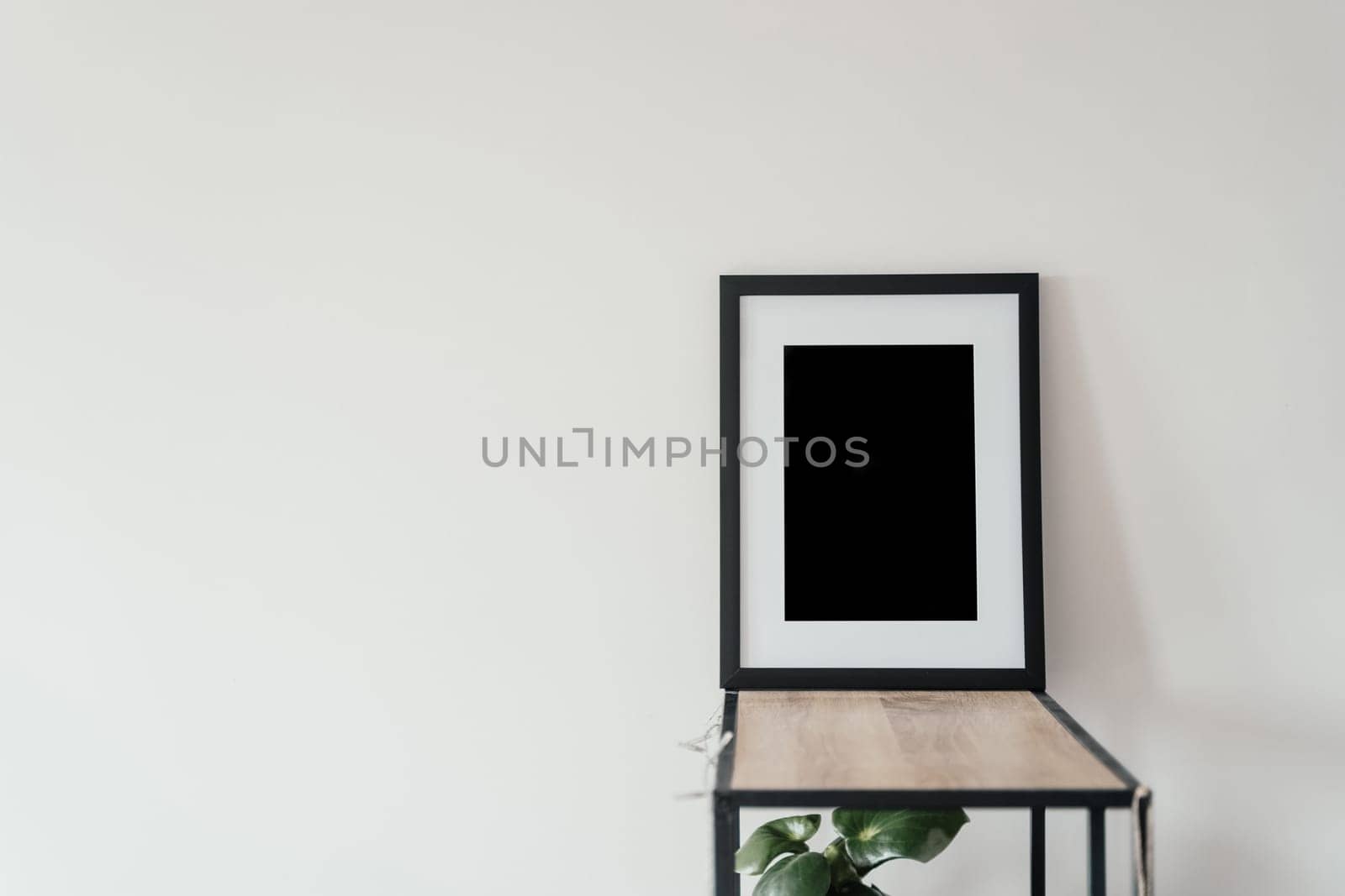 Blank wooden photo frame stands in the interior on a white background. Mockup poster frame. by driver-s