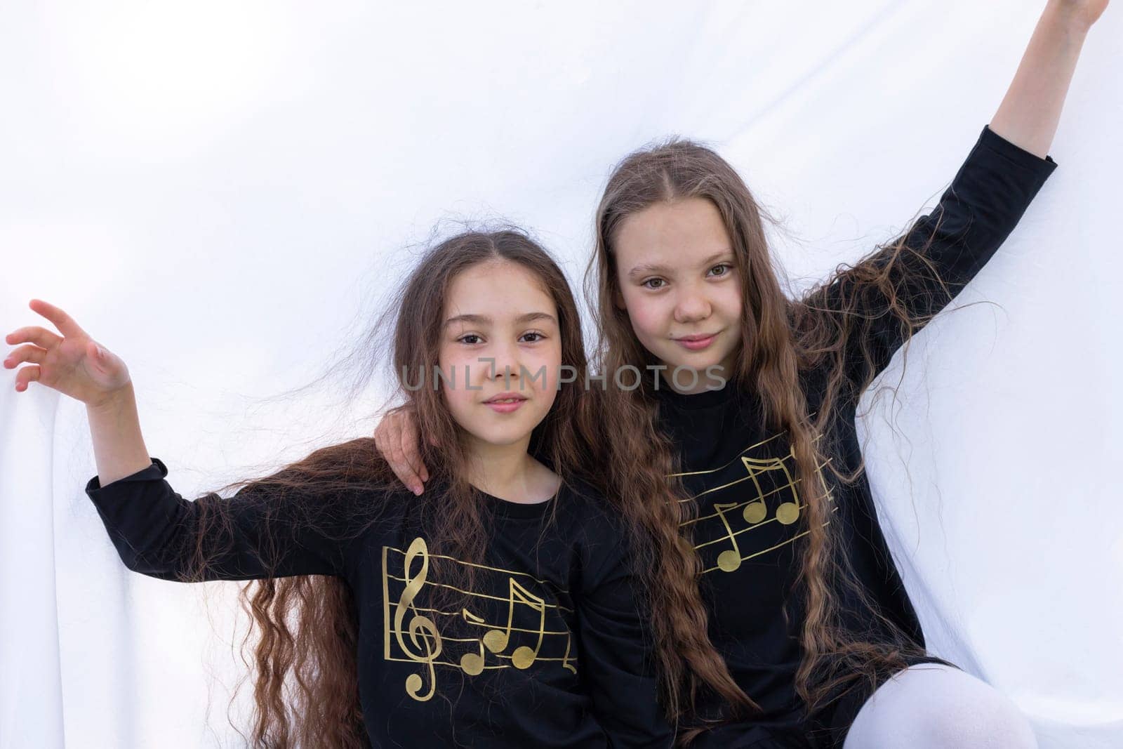 Two Smiling Girls, Sisters With Long Hair Having Fun Under Sheet On Grass in Park, Making Tent. Caucasian Asian Siblings Enjoy Time Together. Carefree Childhood, True Friendship. Horizontal Plane. by netatsi