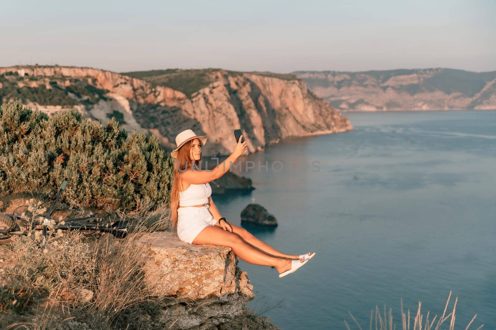 Selfie woman in cap and tank top making selfie shot mobile phone post photo social network outdoors on sea background beach people vacation lifestyle travel concept. by Matiunina