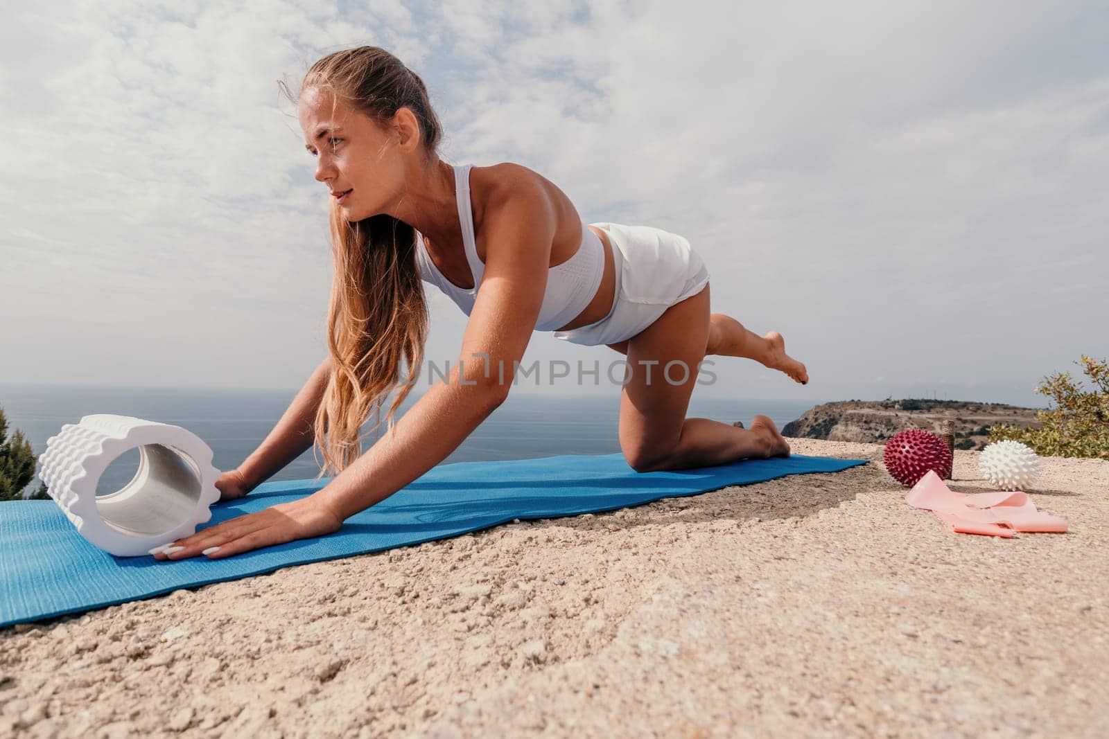 Woman sea pilates. Sporty, middle-aged woman practicing pilates in park near the sea. trains on a yoga mat and exudes a happy and active demeanor, promoting the idea of a healthy lifestyle through exercise and meditation.
