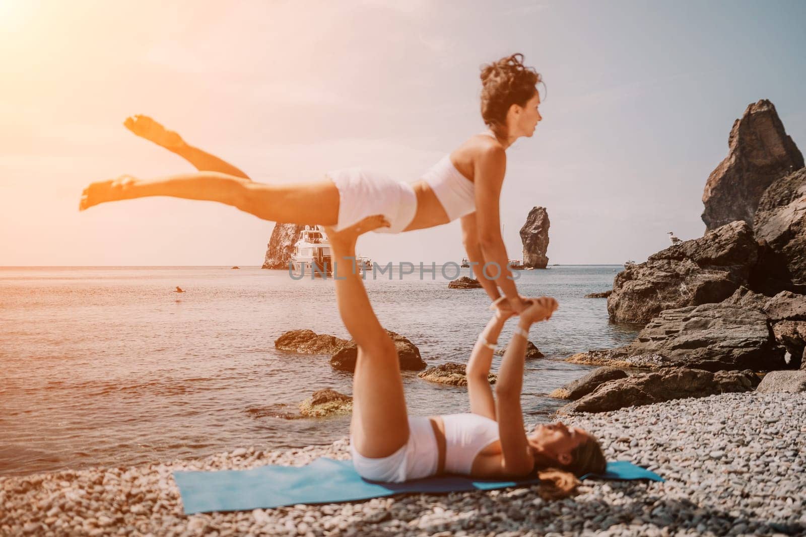 Woman sea yoga. Back view of free calm happy satisfied woman with long hair standing on top rock with yoga position against of sky by the sea. Healthy lifestyle outdoors in nature, fitness concept.