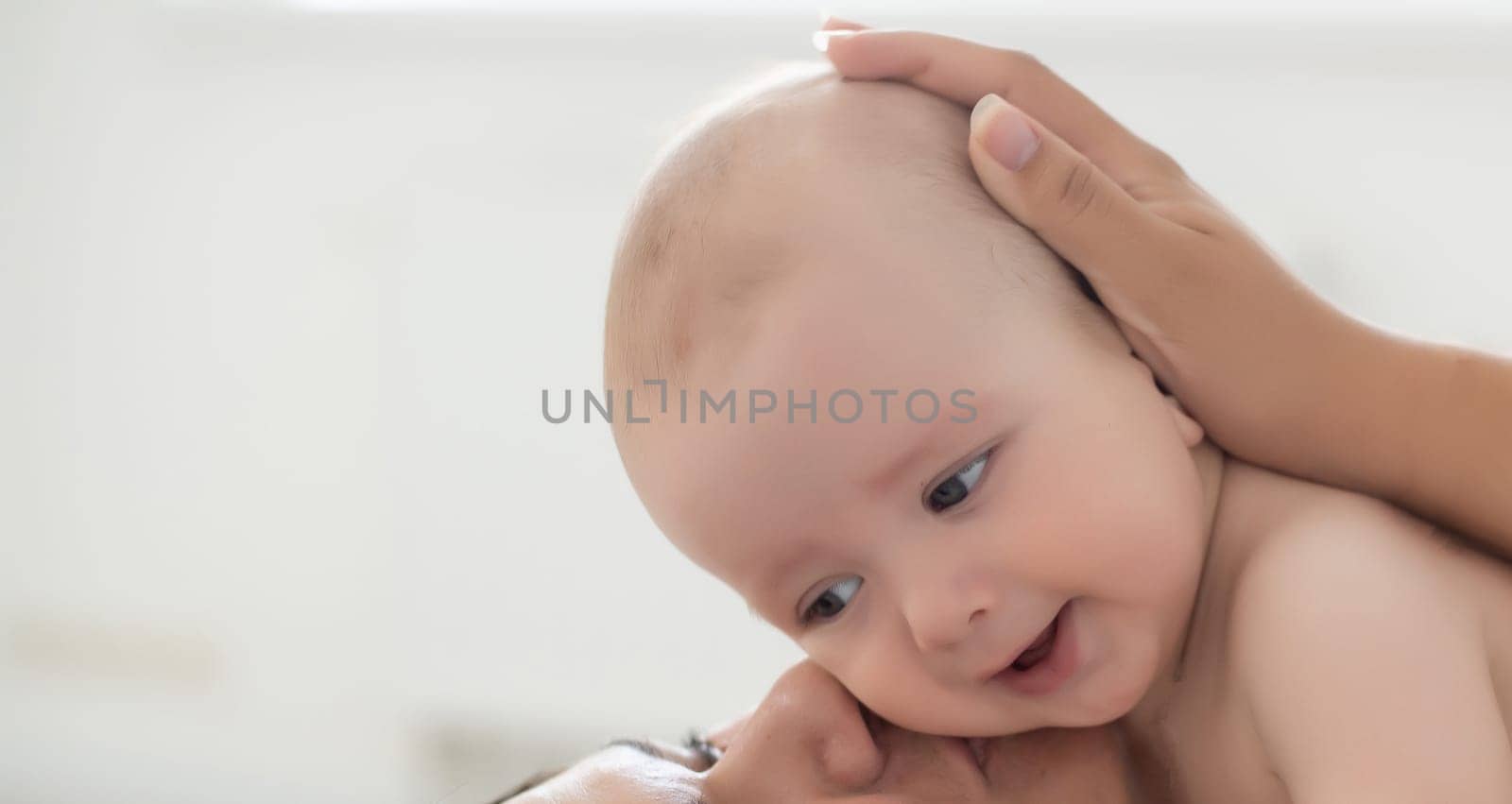 happy family. Mother and baby playing and smiling on bed by Andelov13