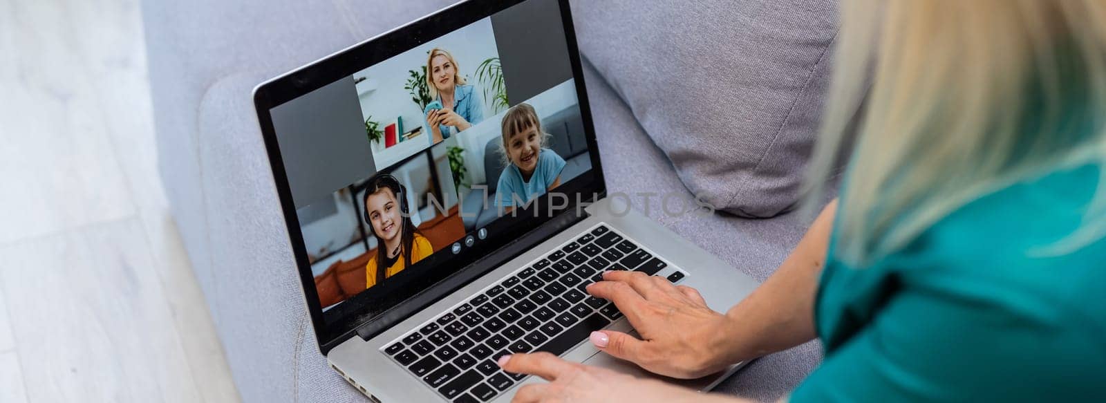 Cropped image of young woman using laptop for video conference at home.