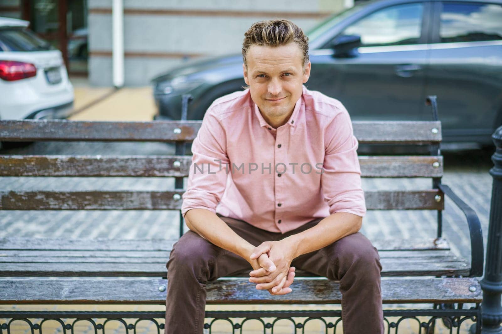 Charismatic and respectable man in portrait, sitting on city bench on street. Man exudes confidence and professionalism, showcasing sophisticated and charming demeanor. . High quality photo
