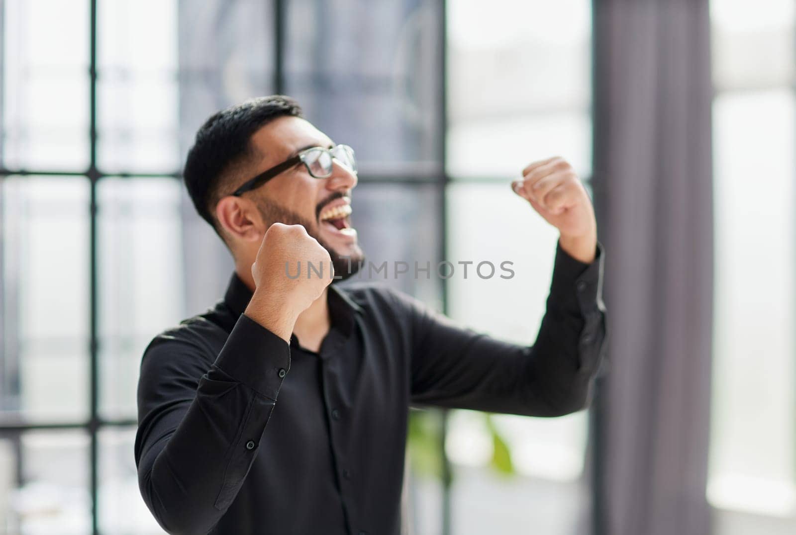 Businessman in stadium crowd, punching air, low angle view