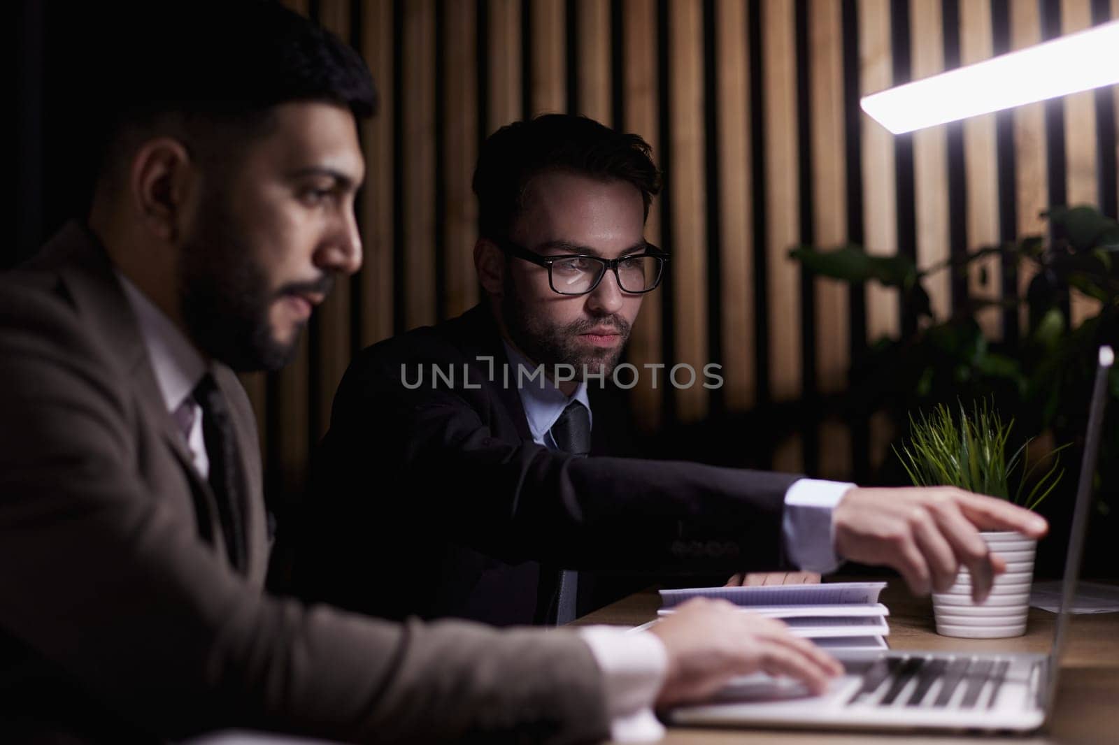 Two middle-aged business workers work at a desk in an office. by Prosto