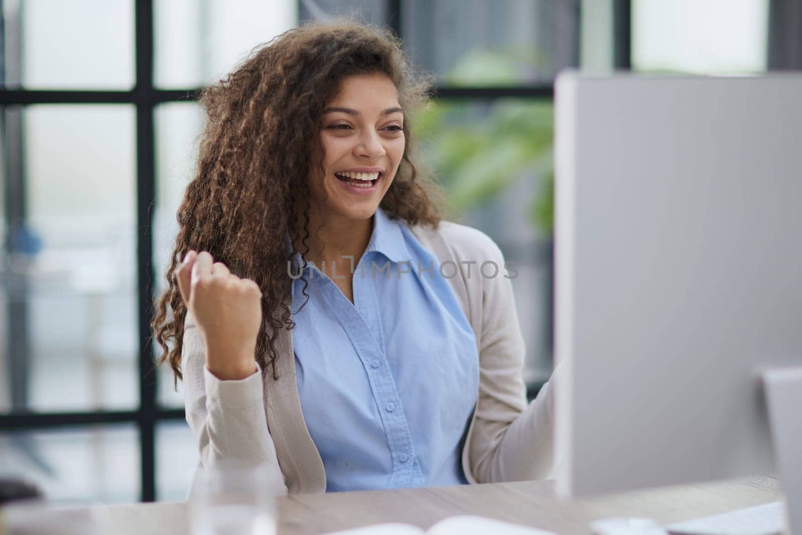 expressive young woman open mouth checking discounts for online shopping sitting at desktop .