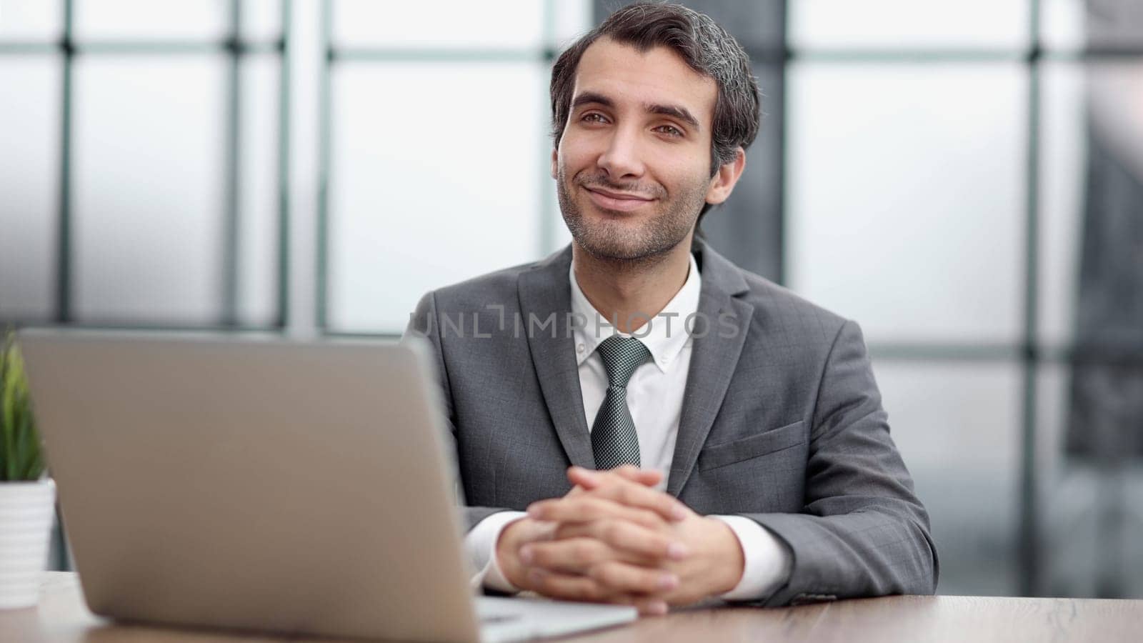 Young man using laptop and smiling at the office