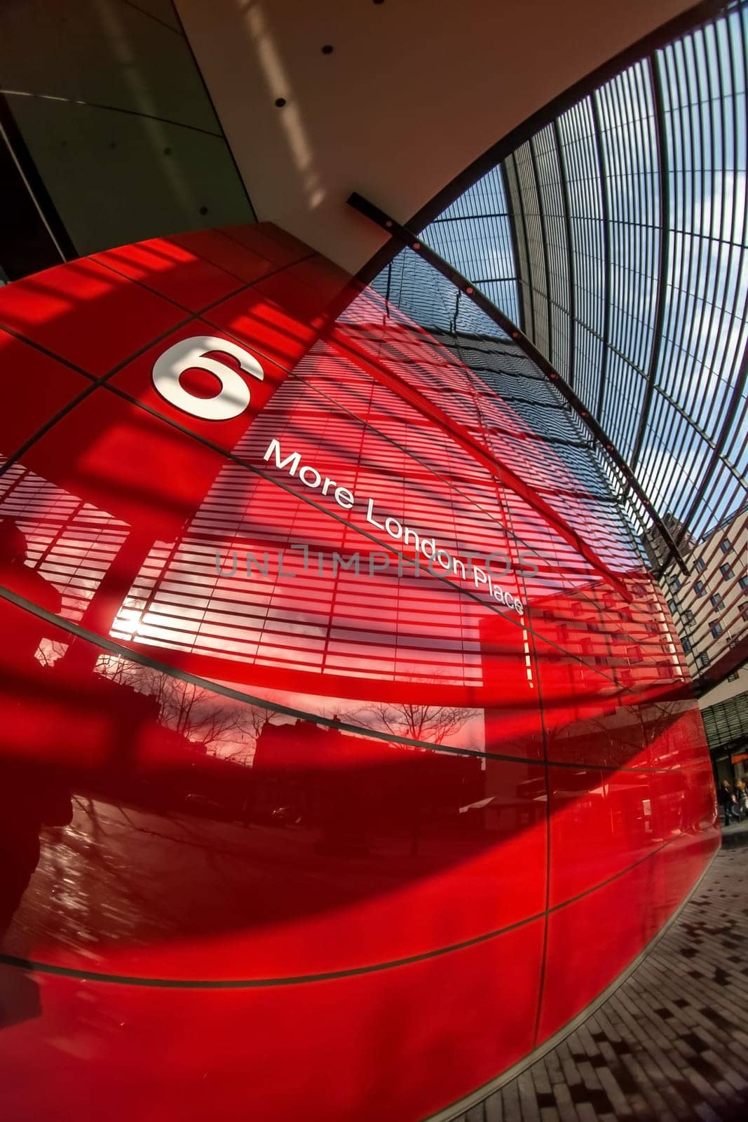 London, United Kingdom - February 10, 2007: Extreme wide (fisheye) photo, red wall of 6 More London Place building designed by Foster and Partners. Example of modern architecture in UK capital. by Ivanko