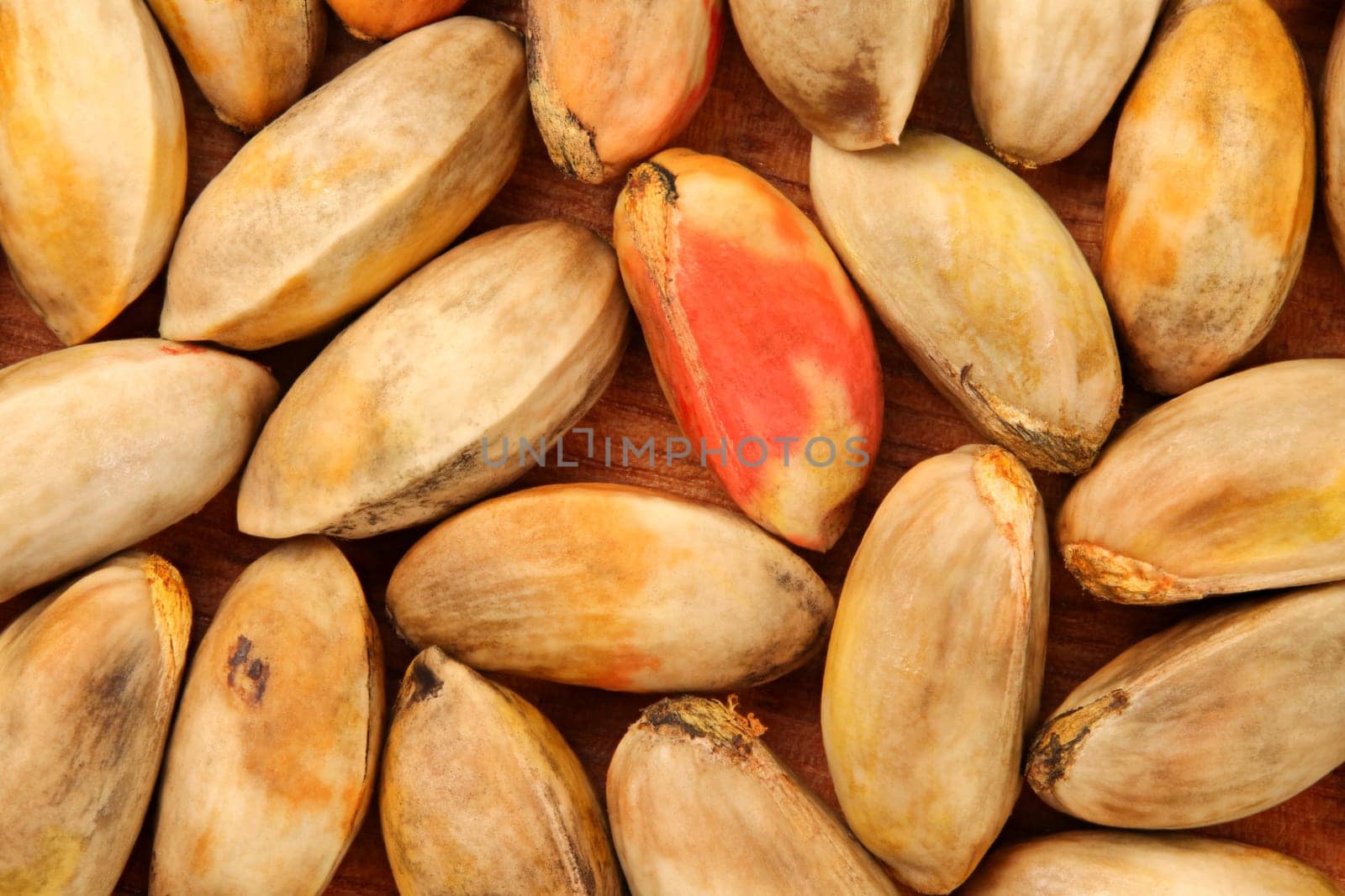 Top down view, unroasted raw pistachios in shell on wooden board.