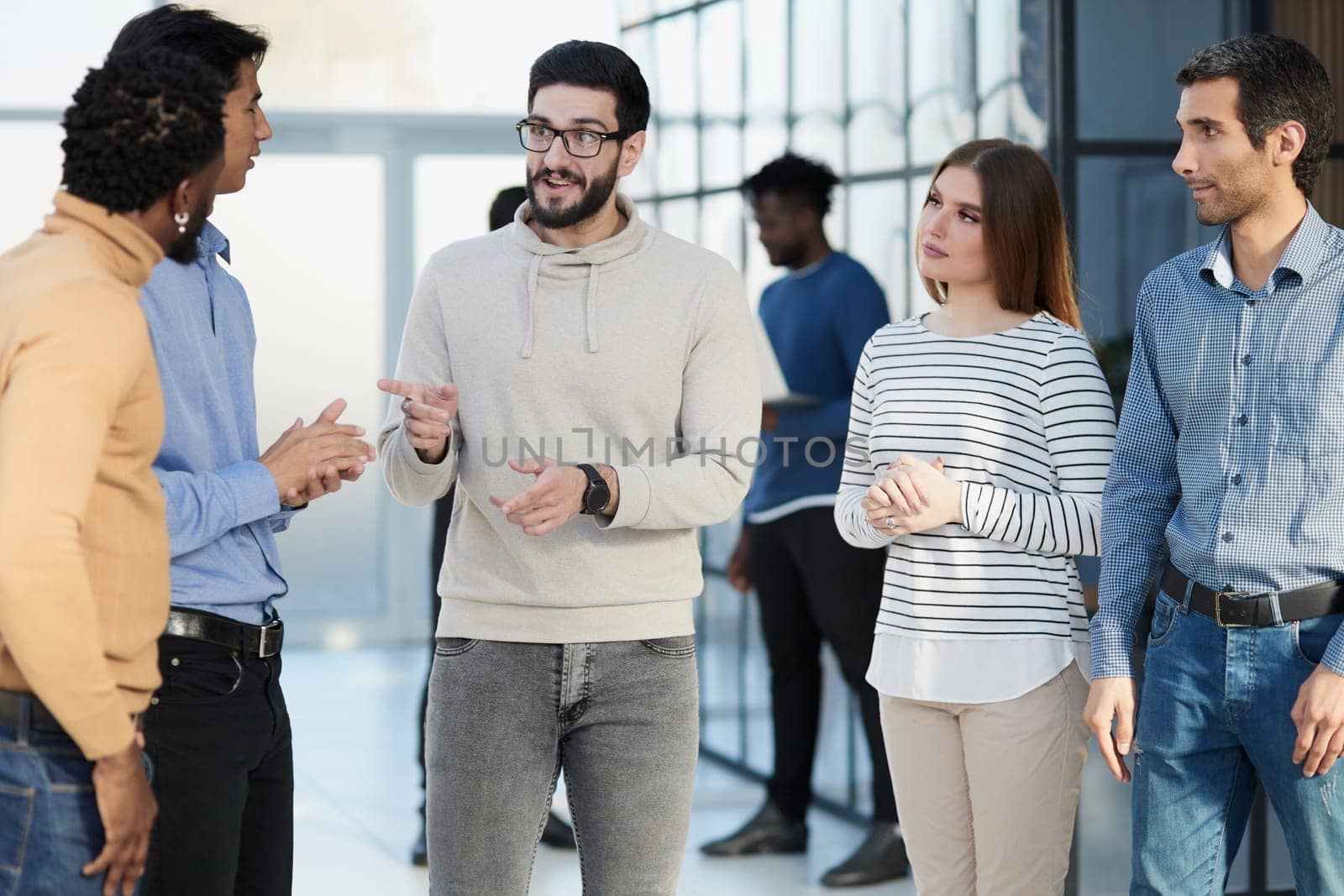 Laughing multiethnic business people talking in the office.
