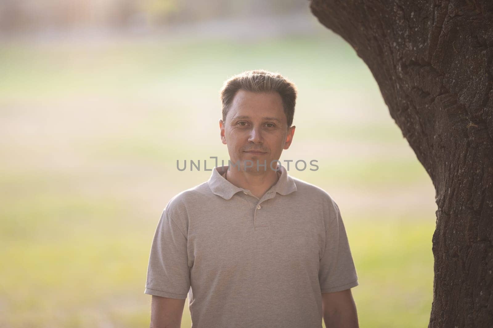 Smiling white man standing on nature. Portrait