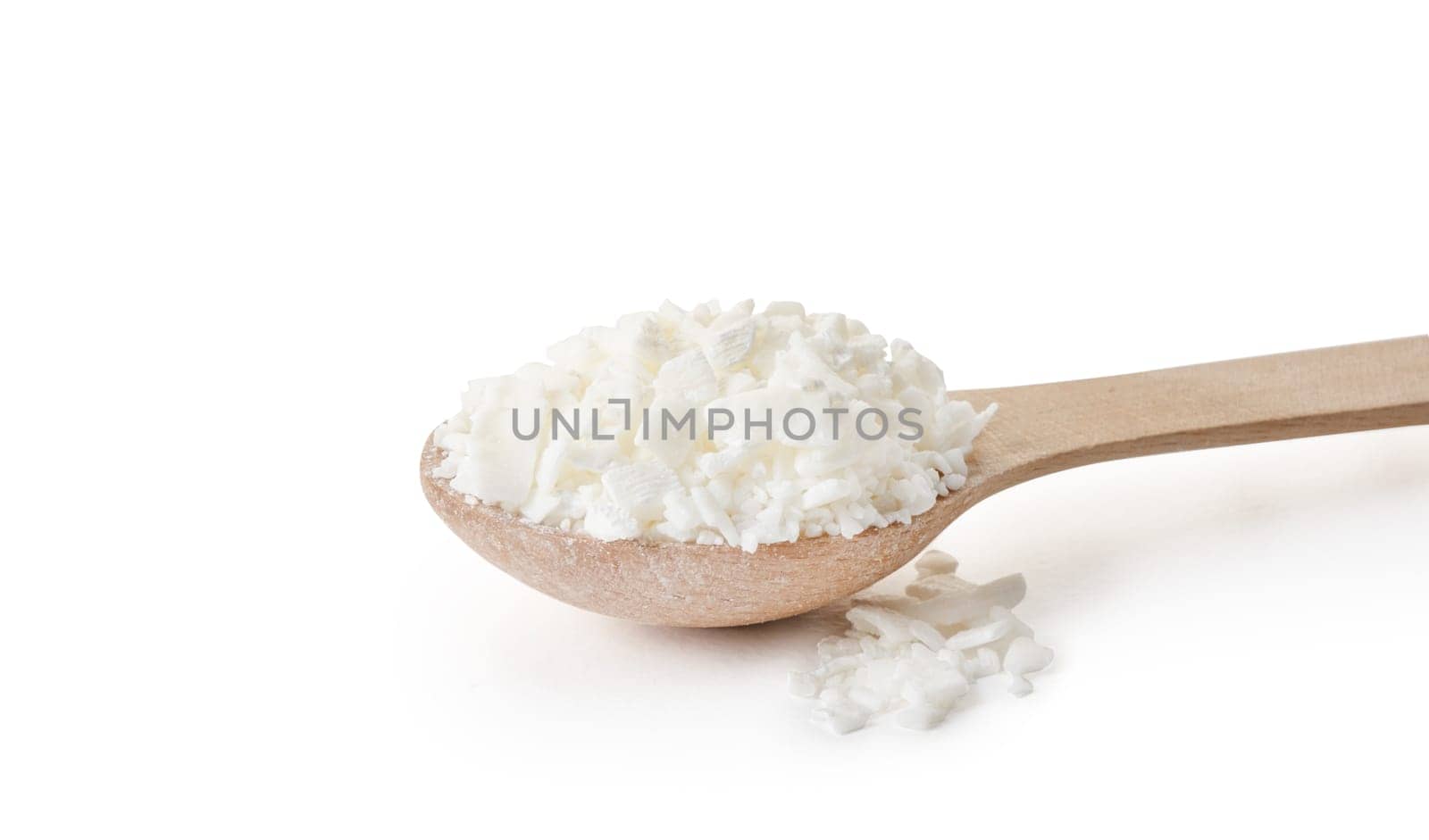 Organic white soy wax flakes for candles in small measure spoon isolated on white background by Desperada