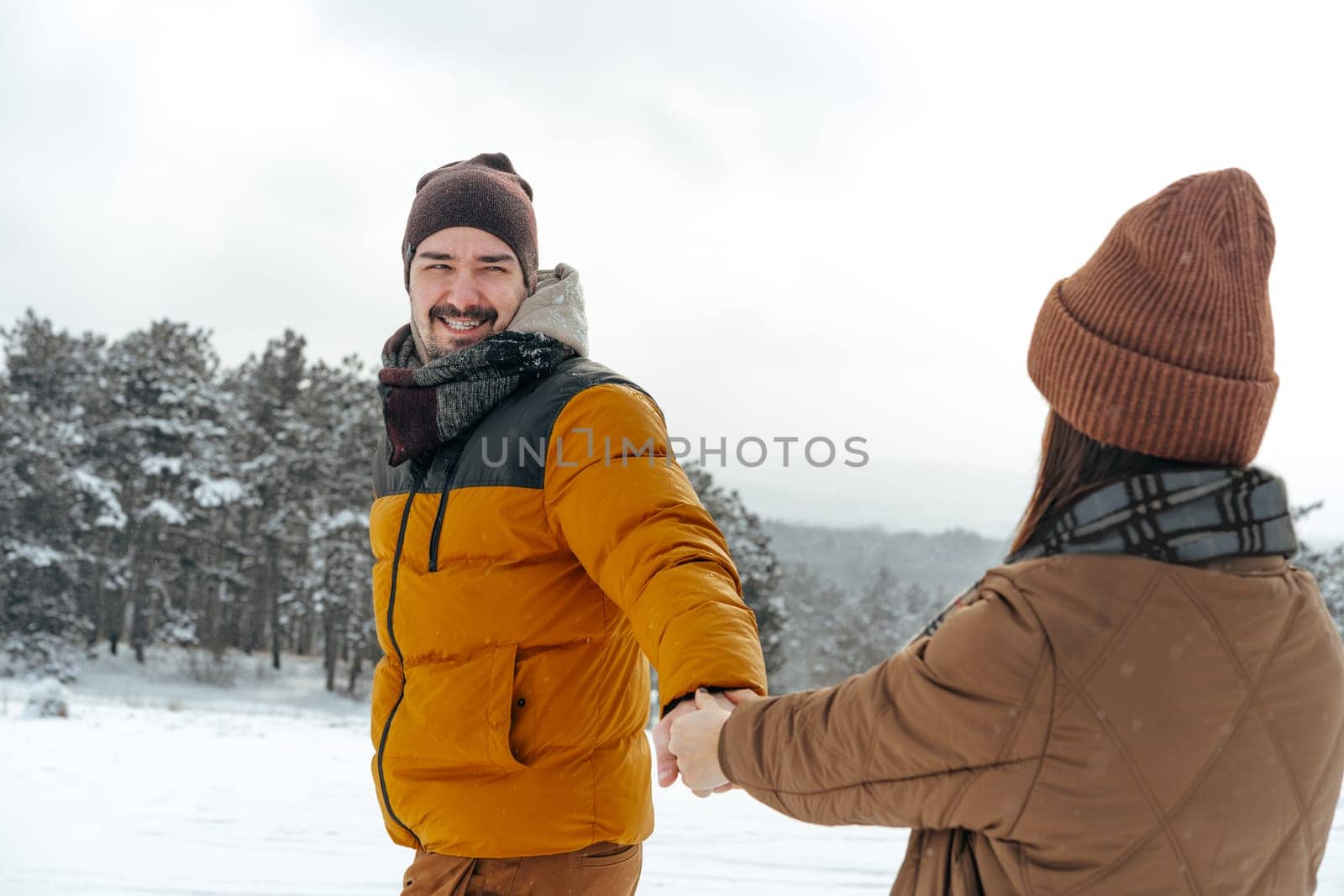Young couple in love outdoor in snowy winter forest. by Fabrikasimf