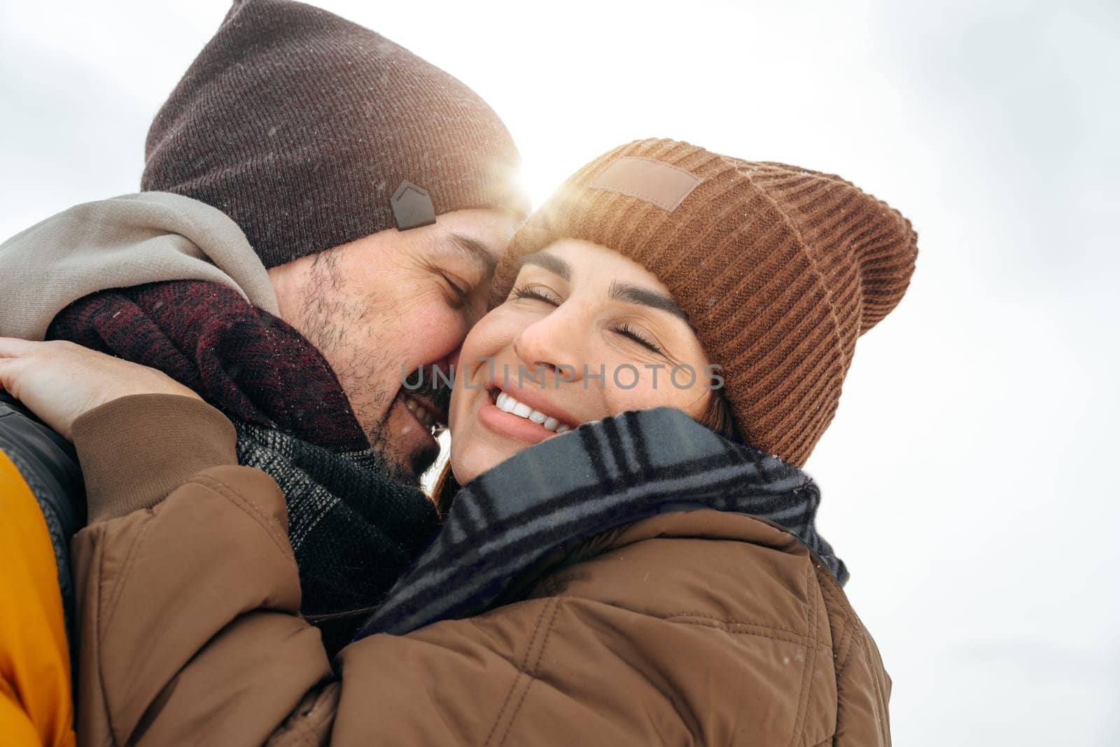 Young couple in love outdoor in snowy winter forest having a walk