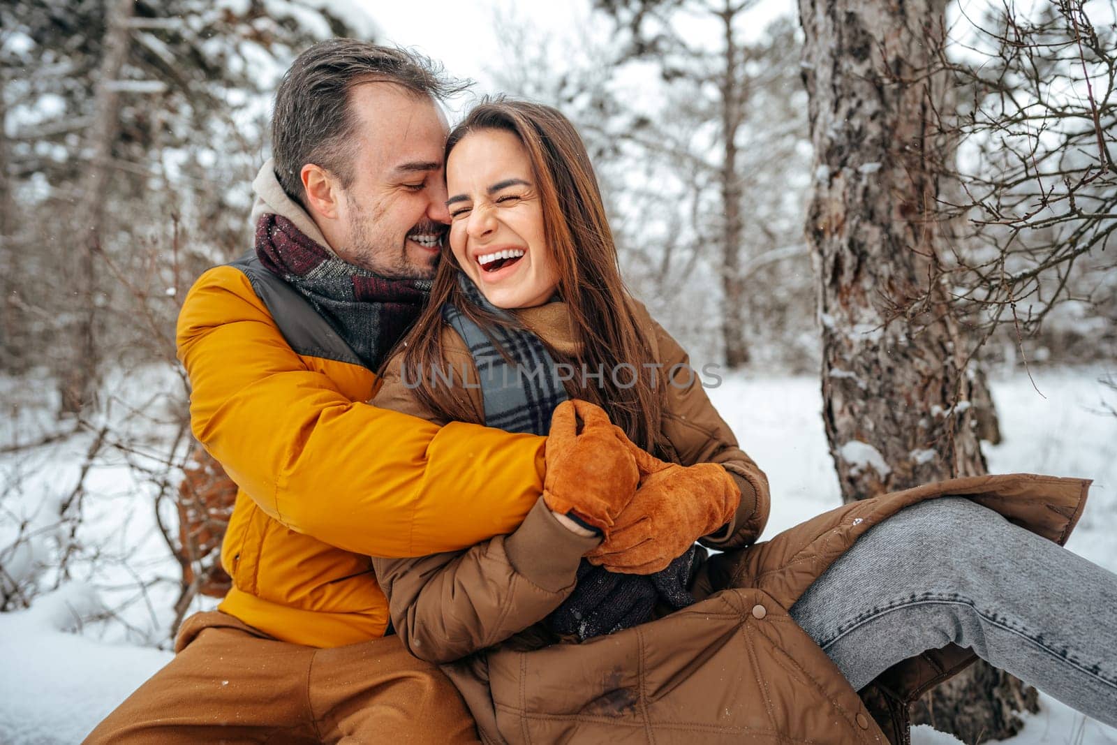 Young couple in love outdoor in snowy winter forest. by Fabrikasimf