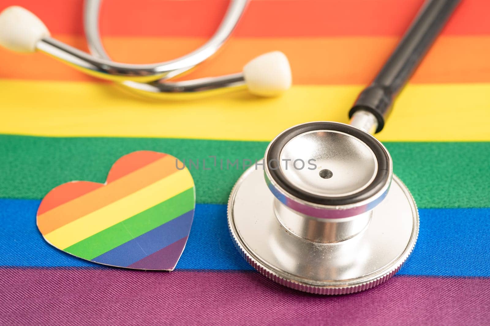 Black stethoscope on rainbow flag with heart, symbol of LGBT pride month celebrate annual in June social, symbol of gay, lesbian, bisexual, transgender, human rights and peace.