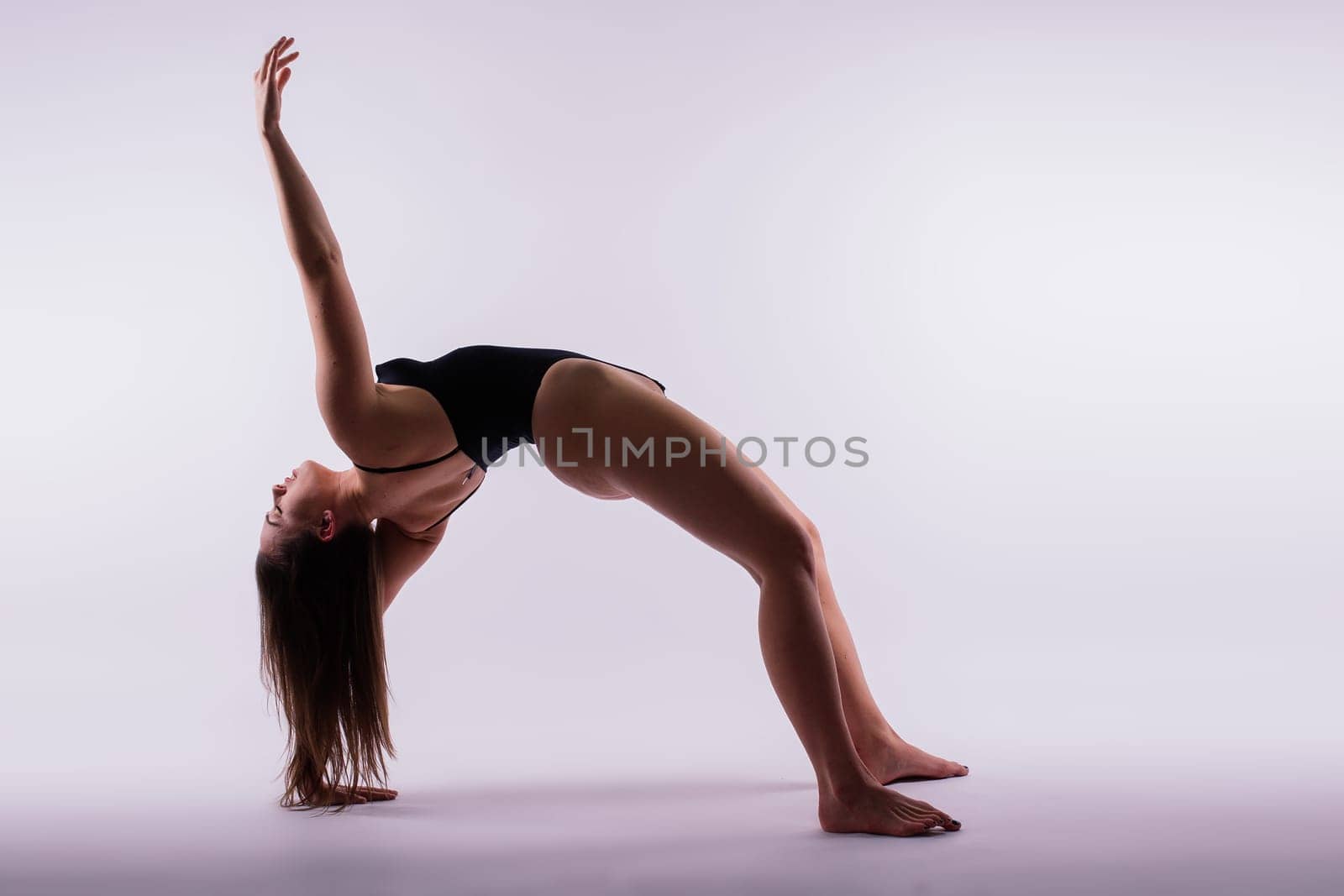 Beautiful woman doing poses on yoga class. Studio shot. by Zelenin