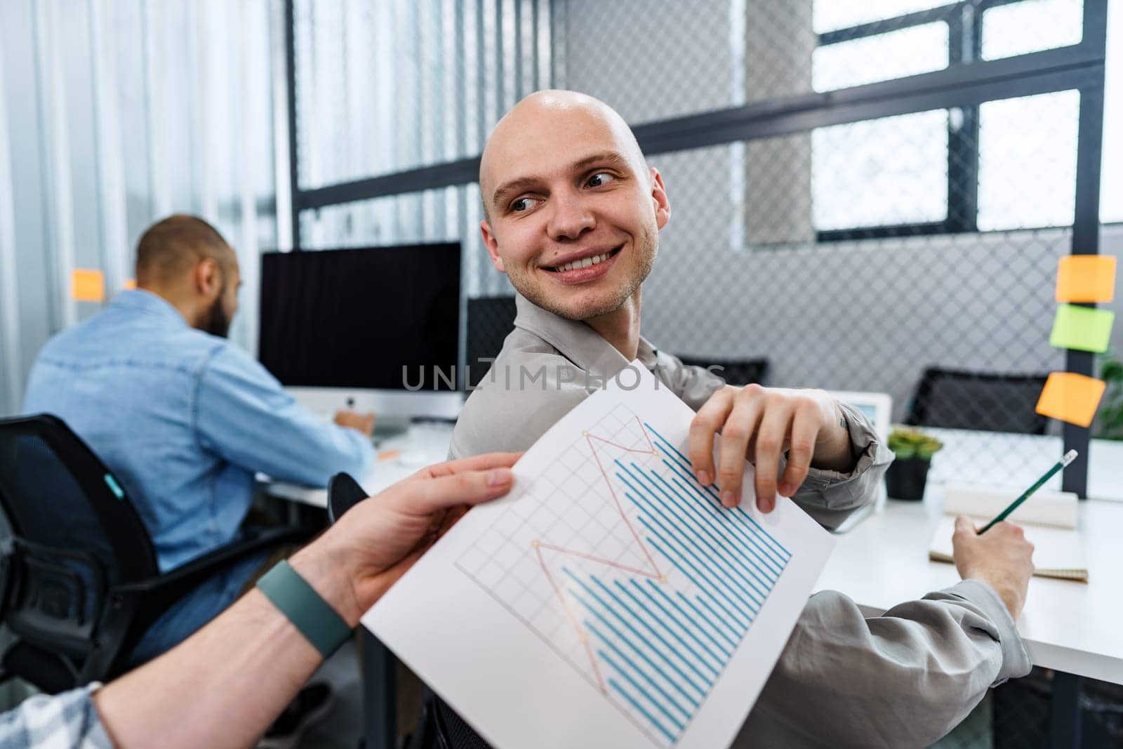 Businessman passing over paper to his colleague in office, close up