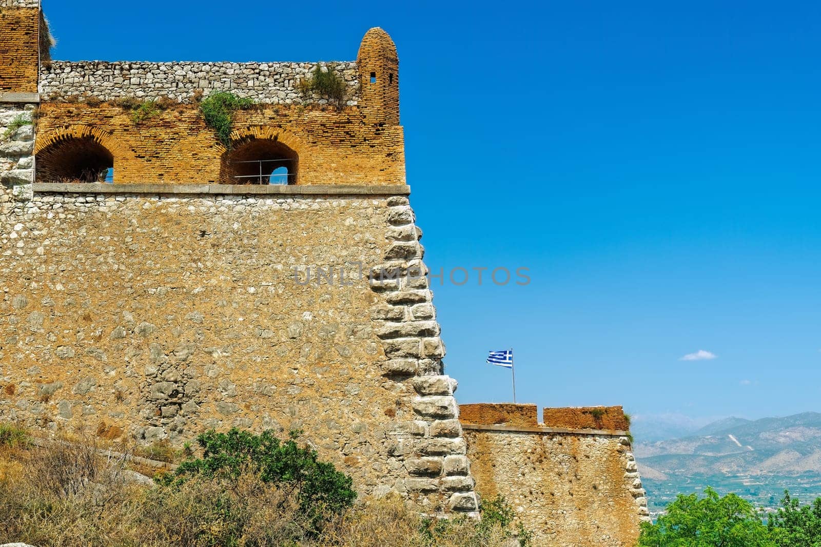 Nafplio, Greece Palamidi fortress bastions Miltiadis and Leonidas with a Greek flag waving against a blue sky.