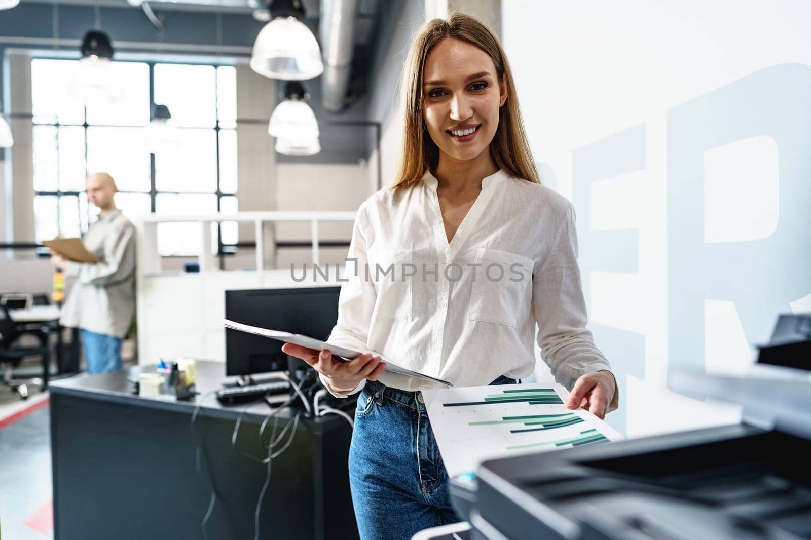Young employee using modern printer in office, close up