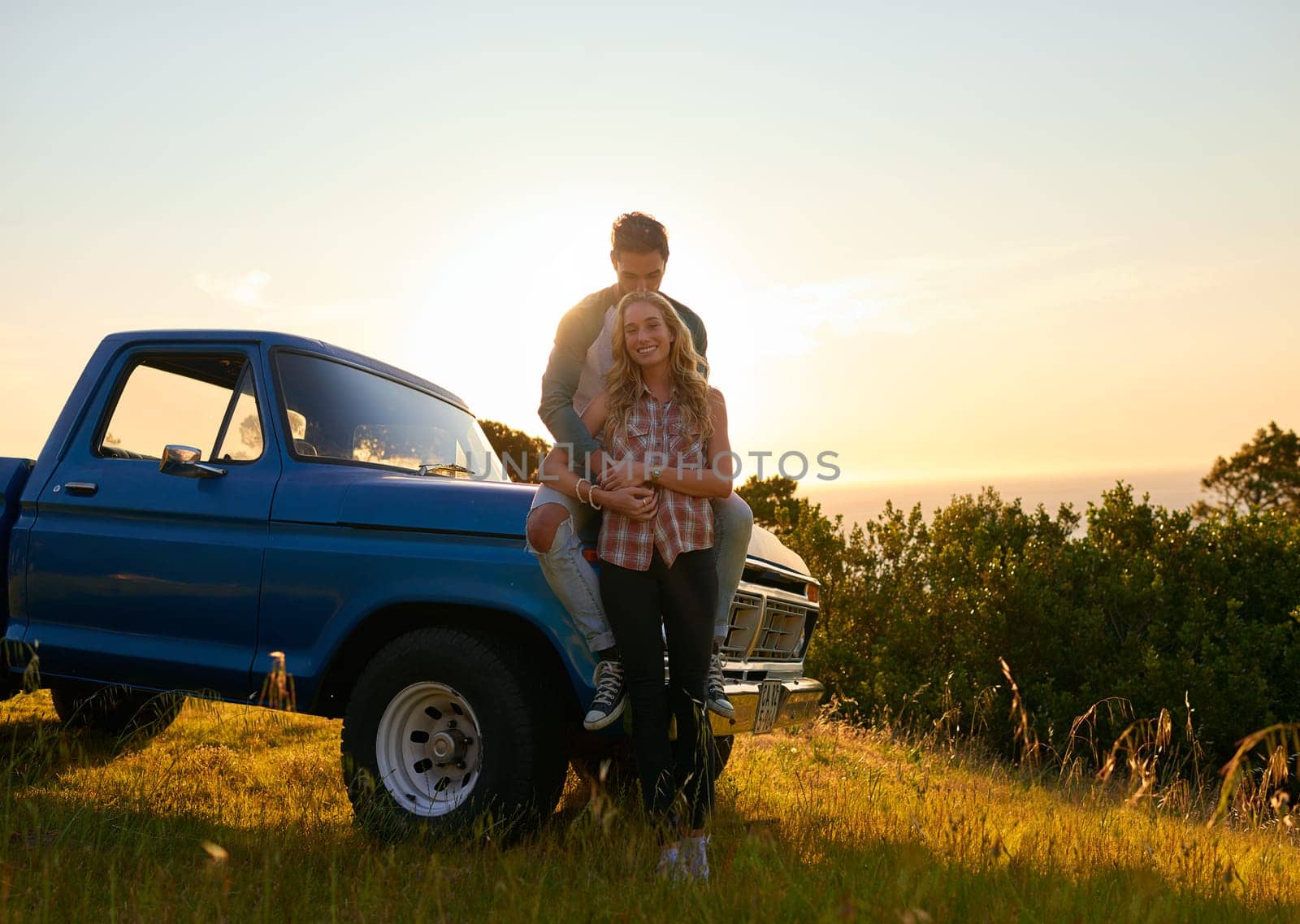 Couple, portrait and sunset by pickup truck in nature for road trip with love, romance and date on adventure. Man, woman and hug for freedom, journey and transportation for travel in countryside.