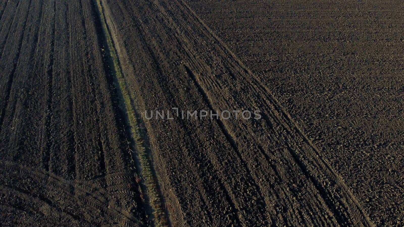 Landscape of plowed up land on agricultural field on sunny autumn day. Flying over plowed earth with black soil. Black soil. Ground earth dirt priming aerial drone view. Agrarian background. Uplift