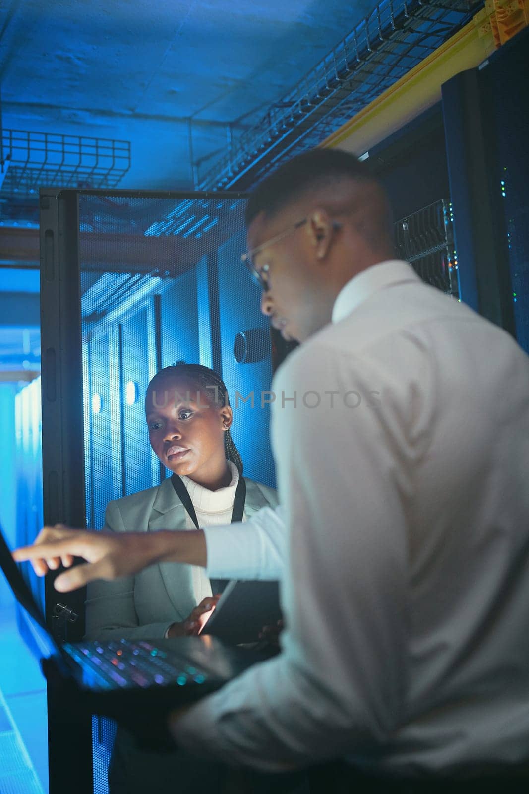 Were suffering from low download speeds. two young IT specialists standing in the server room and having a discussion while using a technology