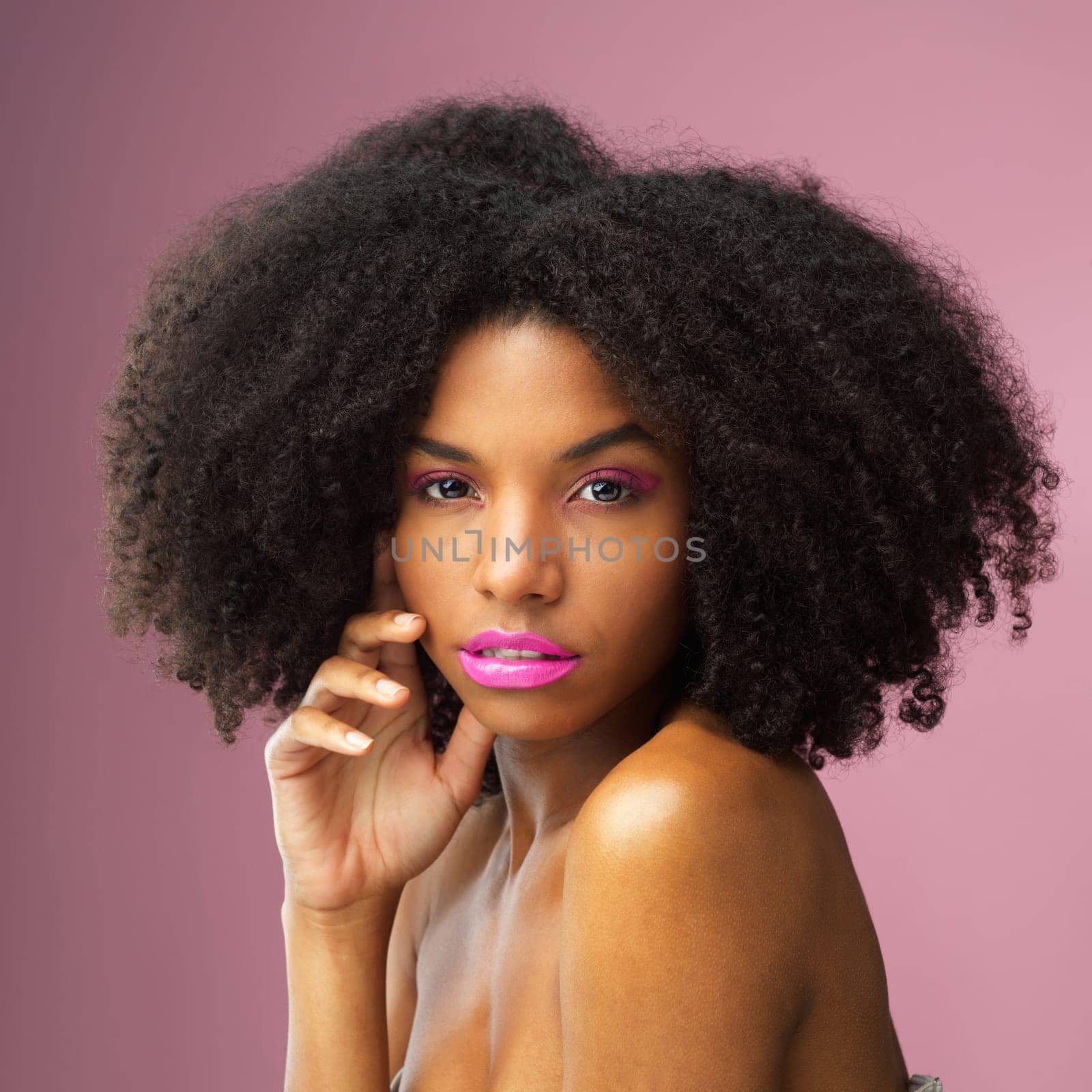 Face, hair care and serious black woman with makeup in studio isolated on a pink background for skincare. Hairstyle portrait, cosmetics and African female model with salon treatment for afro beauty. by YuriArcurs