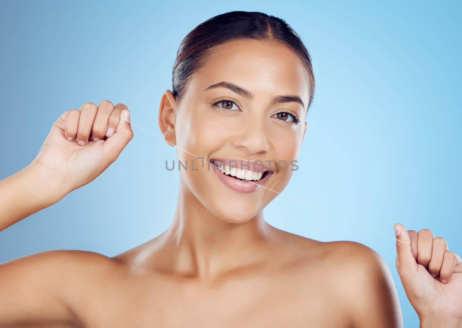 Floss, dental wellness and portrait of woman in studio for beauty, healthy body and hygiene on blue background. Female model, tooth flossing and cleaning mouth for facial smile, breath or happy teeth.