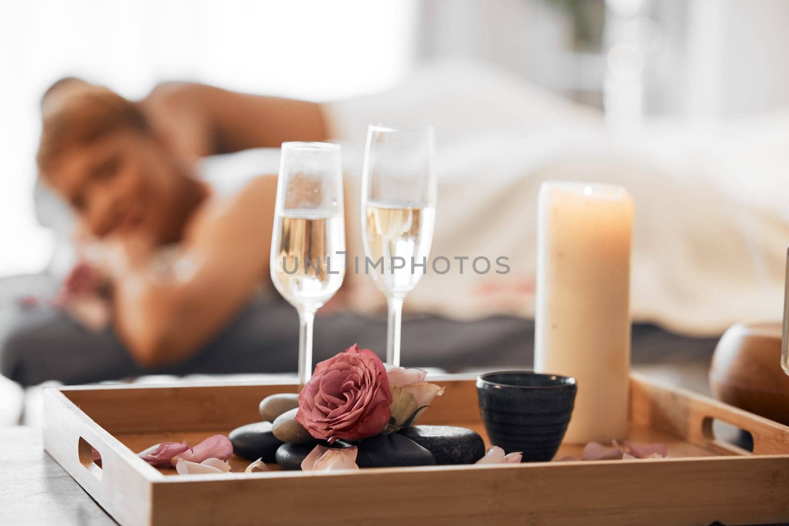 Champagne, spa massage and couple relax in zen, health and wellness salon, romance and body pamper treatment. Luxury, massage and wine at spa by woman and man enjoy peace, cosmetic and stress relief.
