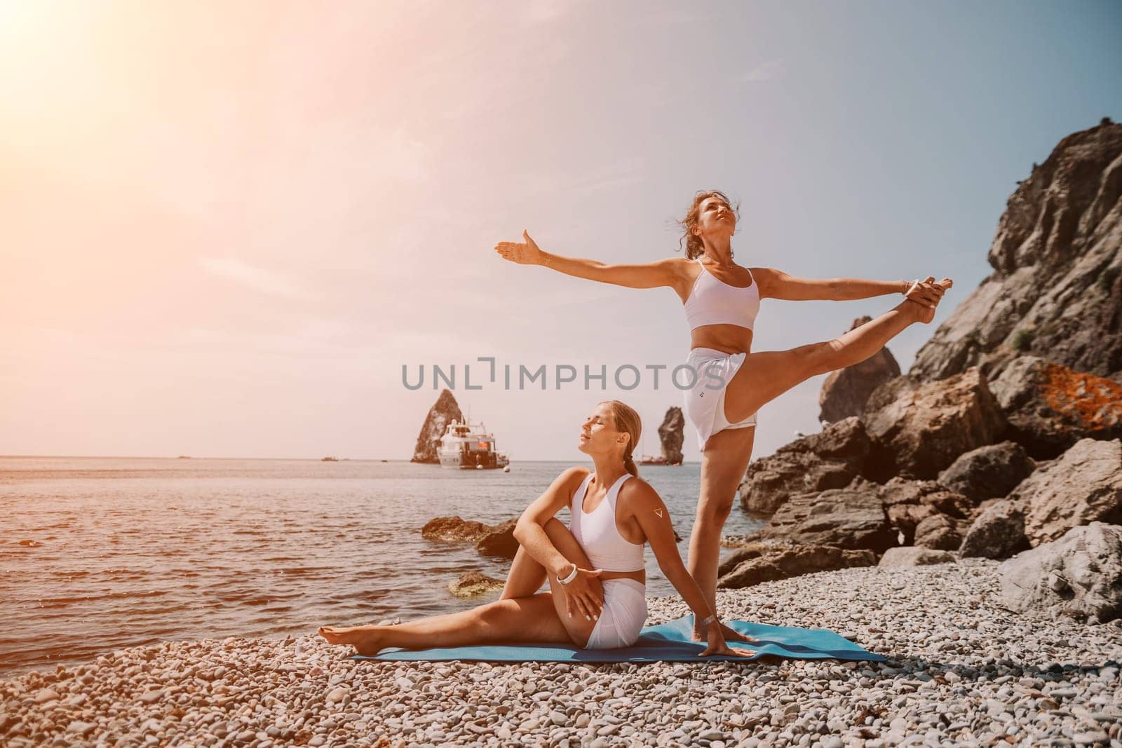 Woman sea yoga. Back view of free calm happy satisfied woman with long hair standing on top rock with yoga position against of sky by the sea. Healthy lifestyle outdoors in nature, fitness concept.