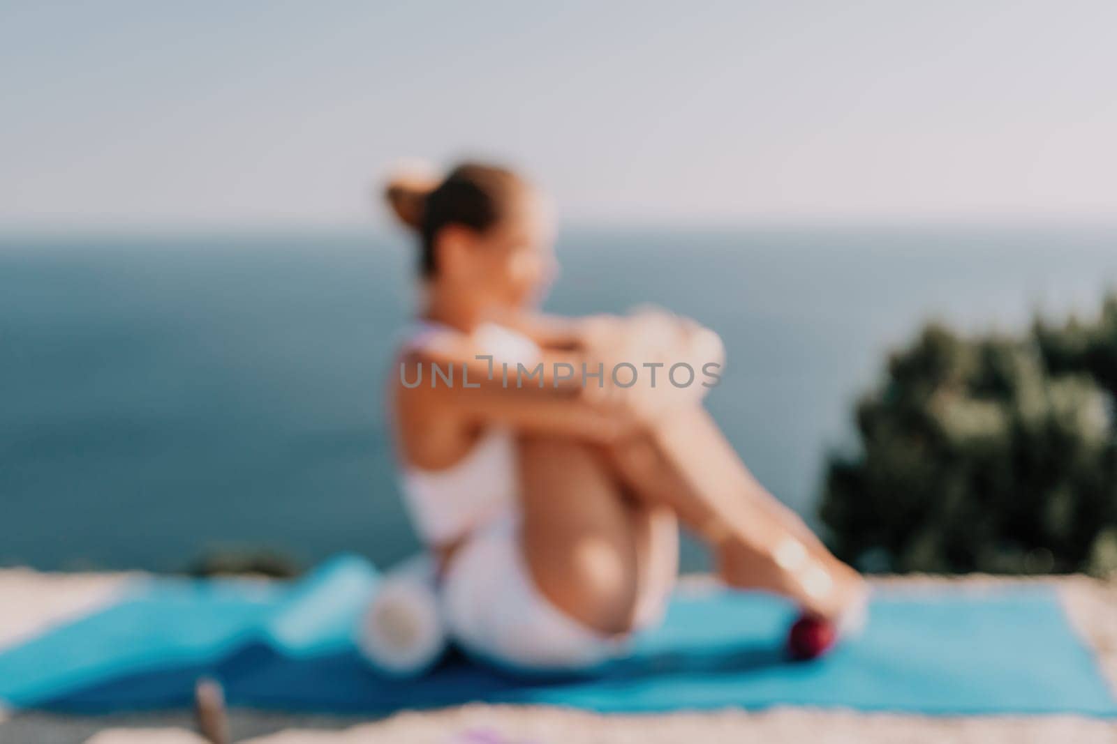 Fitness woman sea. Outdoor workout on yoga mat in park near to ocean beach. Female fitness pilates yoga routine concept. Healthy lifestyle. Happy fit woman exercising with rubber band in park.
