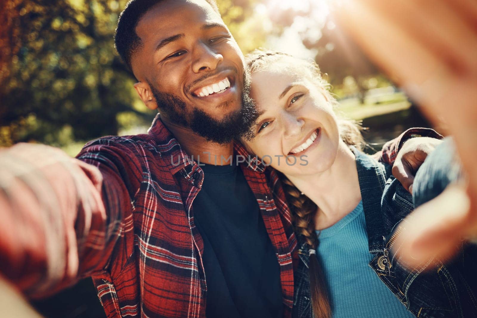 Diversity couple, love selfie and portrait outdoors, having fun and bonding together in nature. Comic smile, interracial romance and black man and woman take pictures for happy memory or social media by YuriArcurs