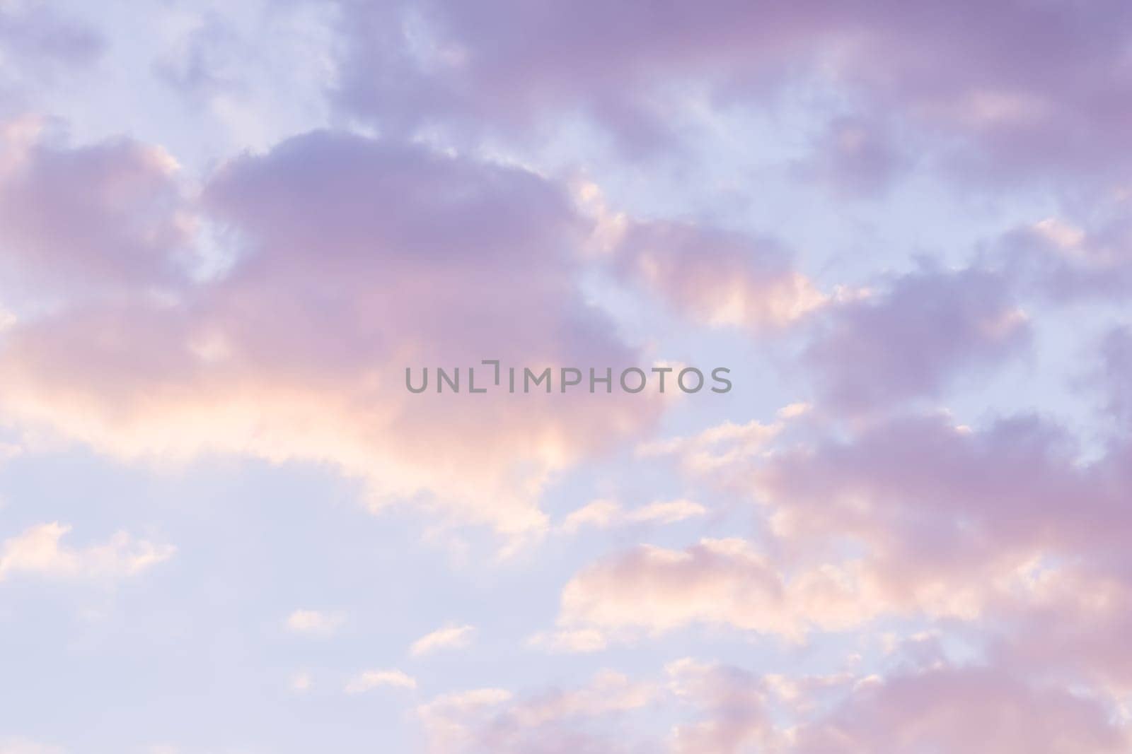 Background of blue sky with pale pink clouds at sunset