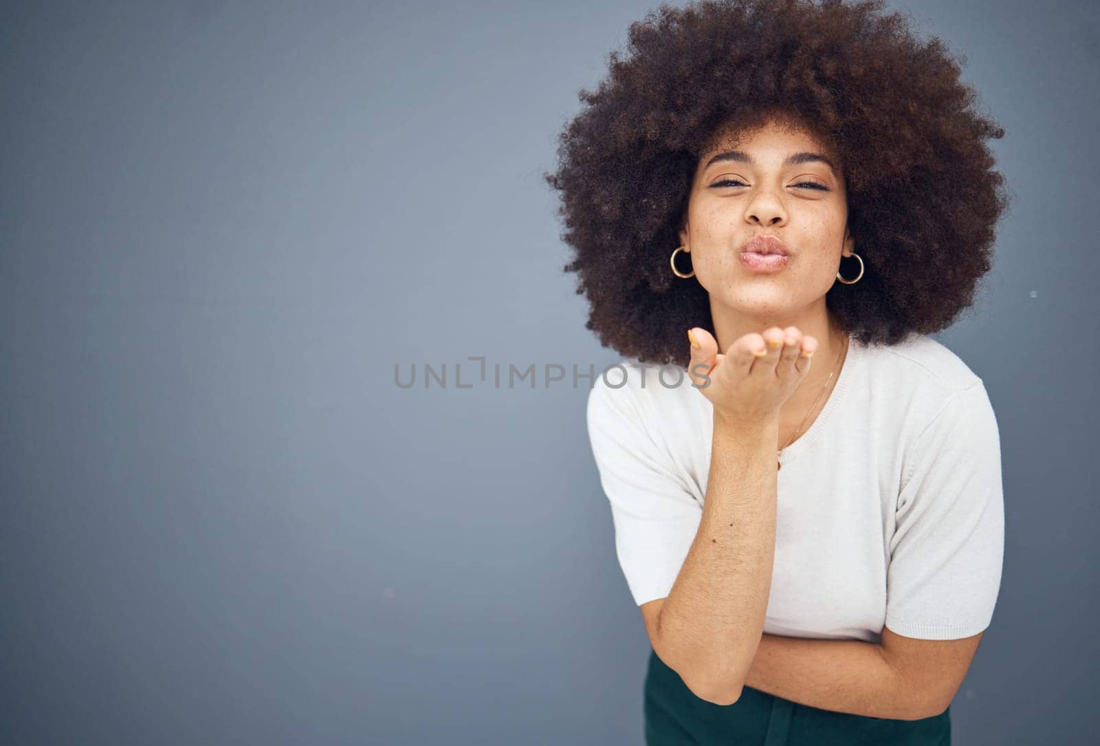 Blow kiss, black woman and mockup showing love, smile and happy kissing with beauty. Model from New York with natural hair, happiness and mock up space loving romance and skincare wellness in studio by YuriArcurs