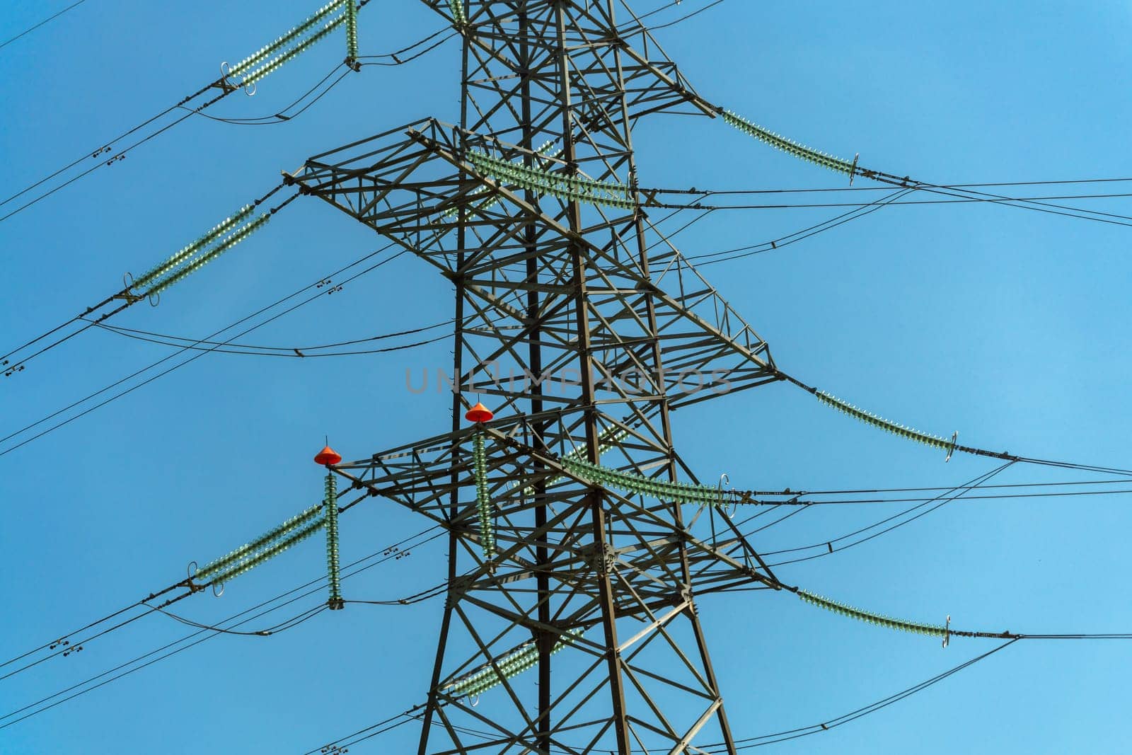 High voltage towers with sky background. Power line support with wires for electricity transmission. High voltage grid tower with wire cable at distribution station. Energy industry, energy saving.