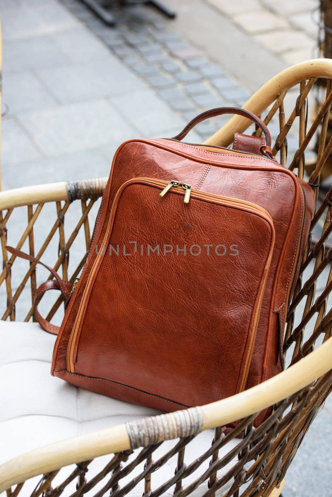 photo of a orange leather backpack with antique and retro look. outdoors photo by Ashtray25