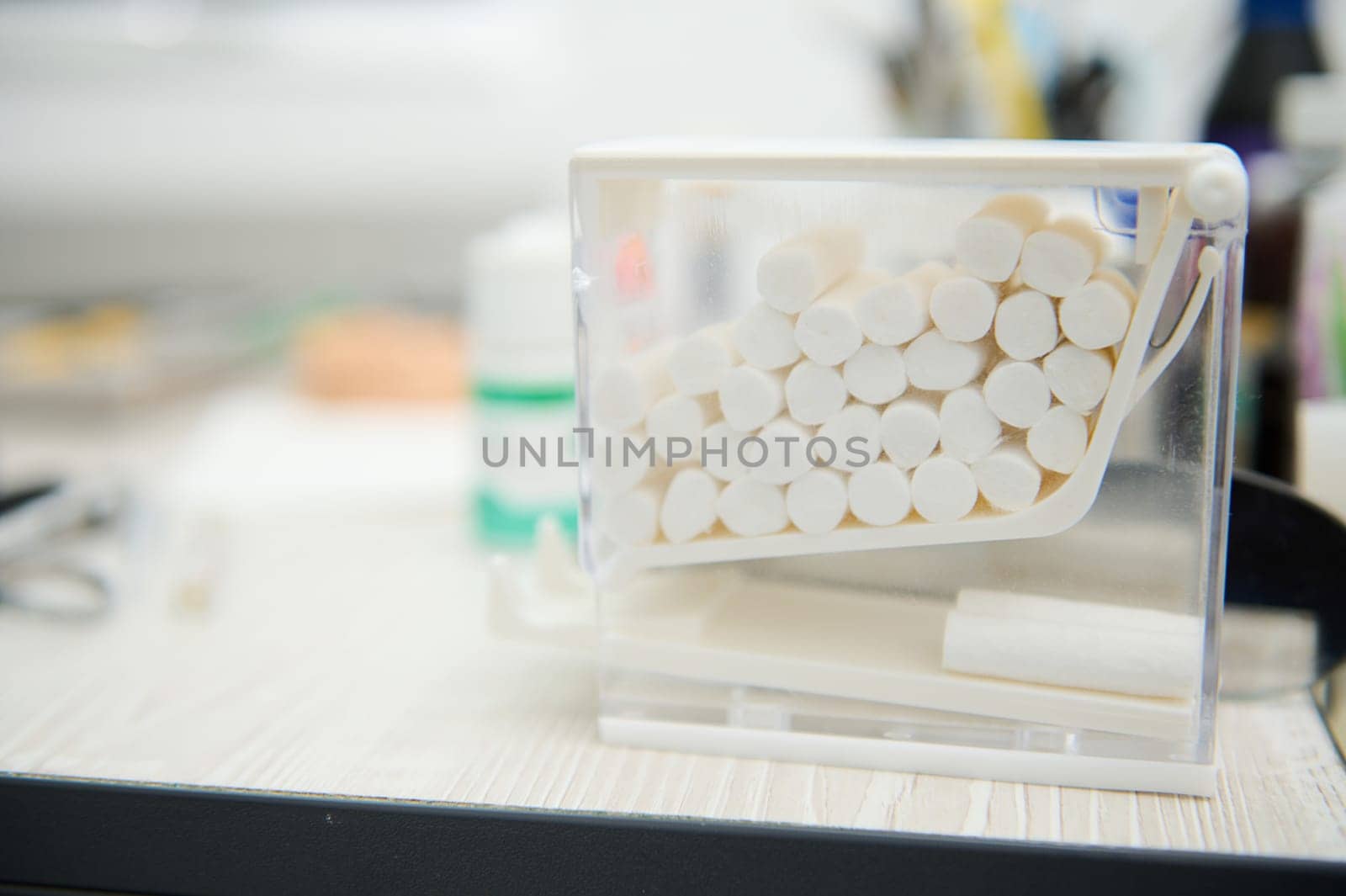 Selective focus. Close-up of cotton swabs inside a transparent container in the dental clinic