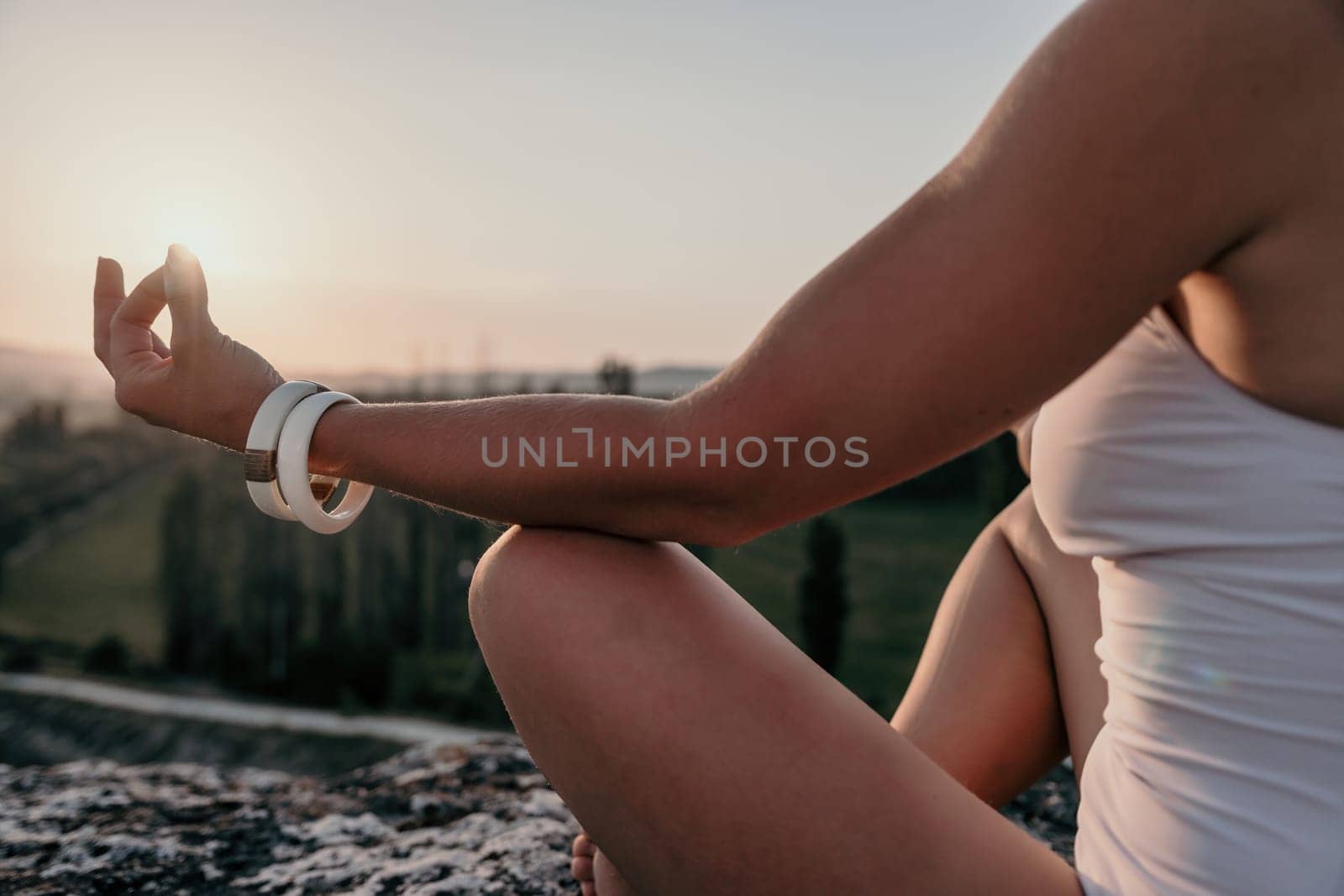 Young woman with black hair, fitness instructor in pink sports leggings and tops, doing pilates on yoga mat with magic pilates ring by the sea on the beach. Female fitness daily yoga concept