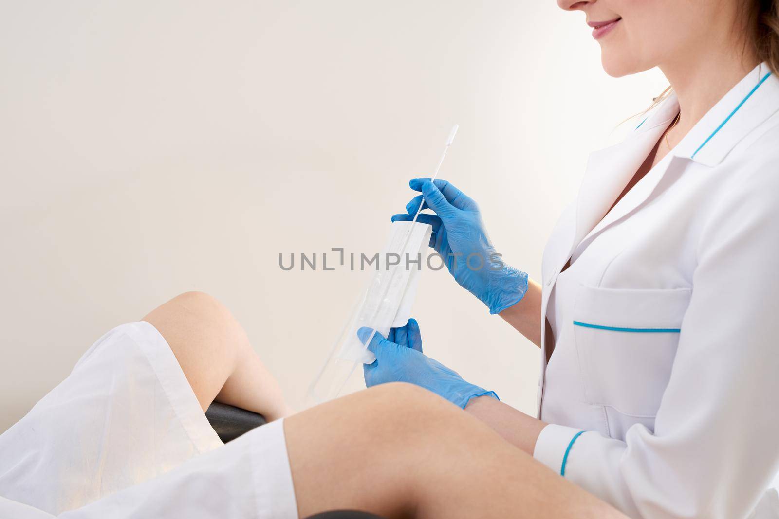 Gynecologist using vaginal swab for STD testing. Woman in gynecological chair