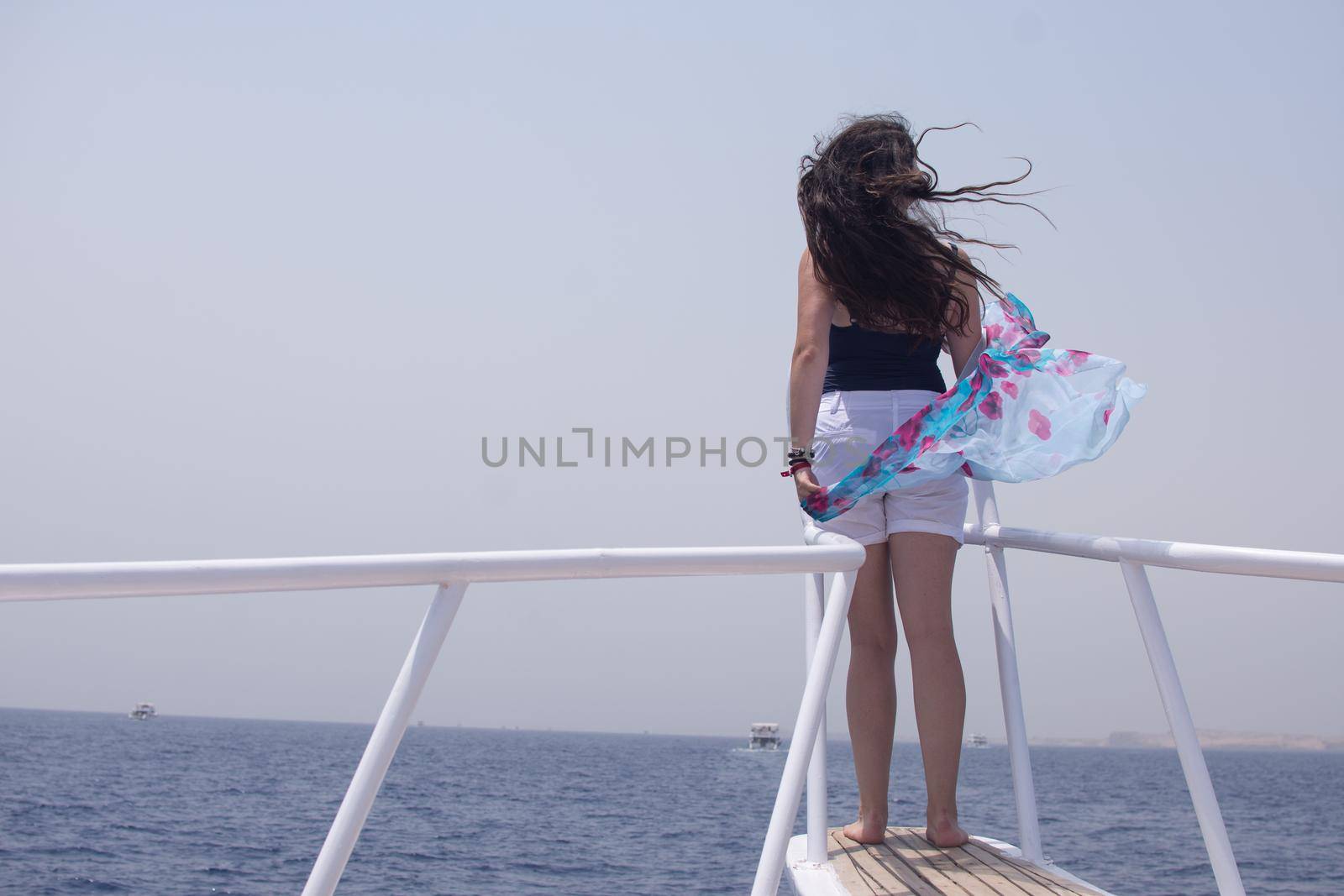 a young woman on the bow of a yacht looks at the sea. a tourist girl on a ship in the red sea. tourist tour in Egypt.