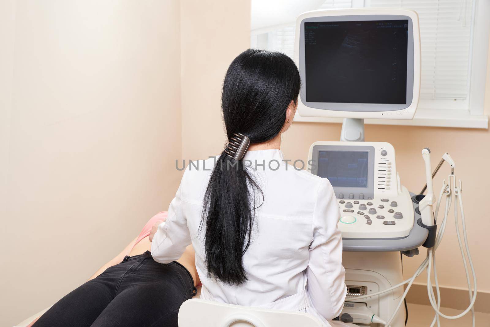 Doctor conducting the ultrasound procedure to pregnant woman