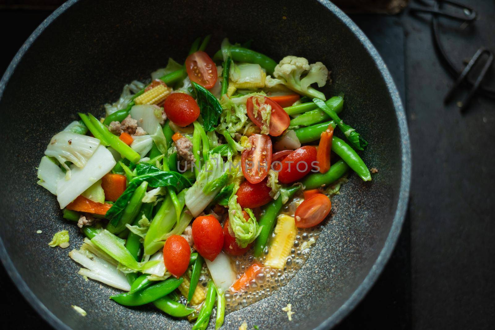 fried vegetables on the pan in the kitchen by Wmpix