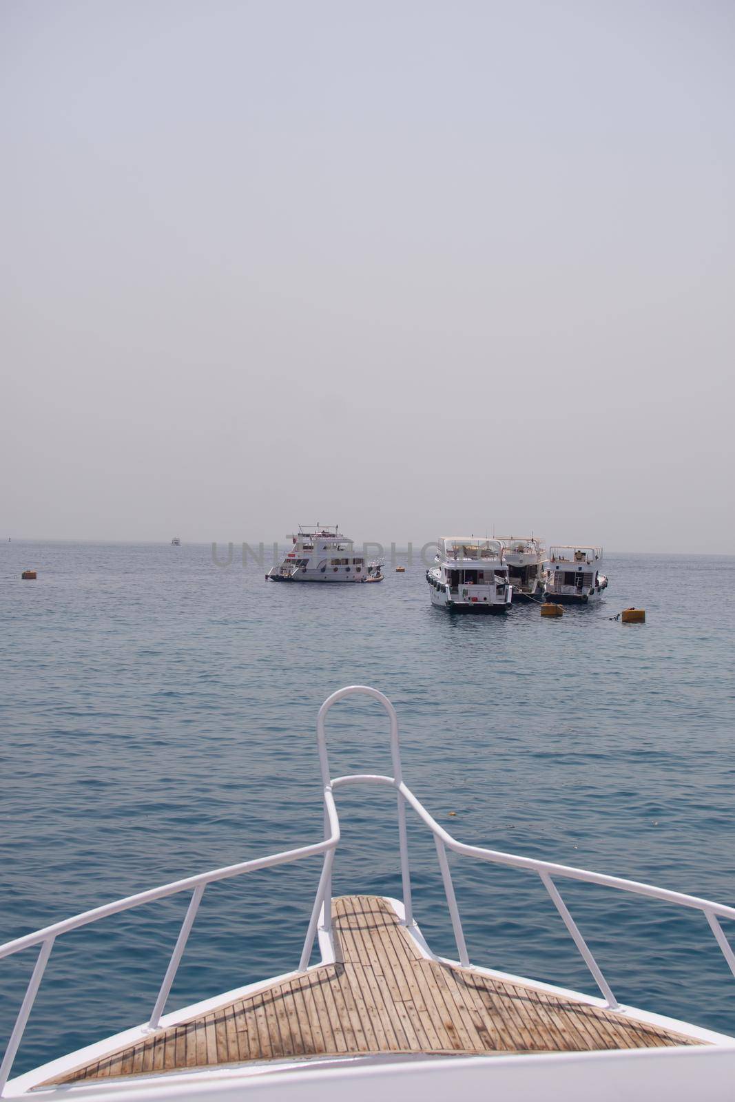 the bow of the yacht. close-up view from the deck. there are other yachts ahead. red sea, Egypt. vertical photo.