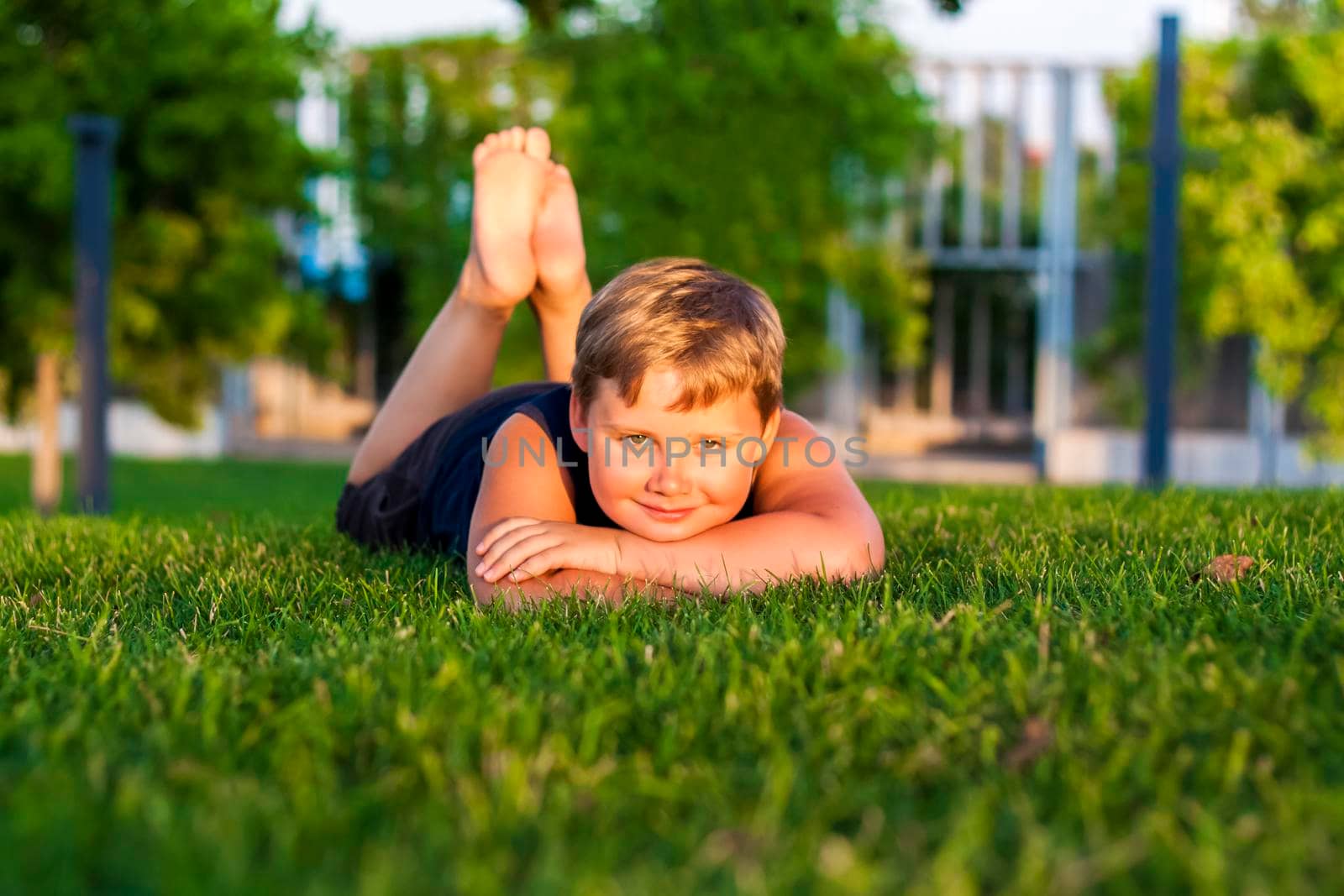 The child spends time in the park, he is very happy. Have fun and enjoy a summer day. Walking and recreation. Portrait of a happy child