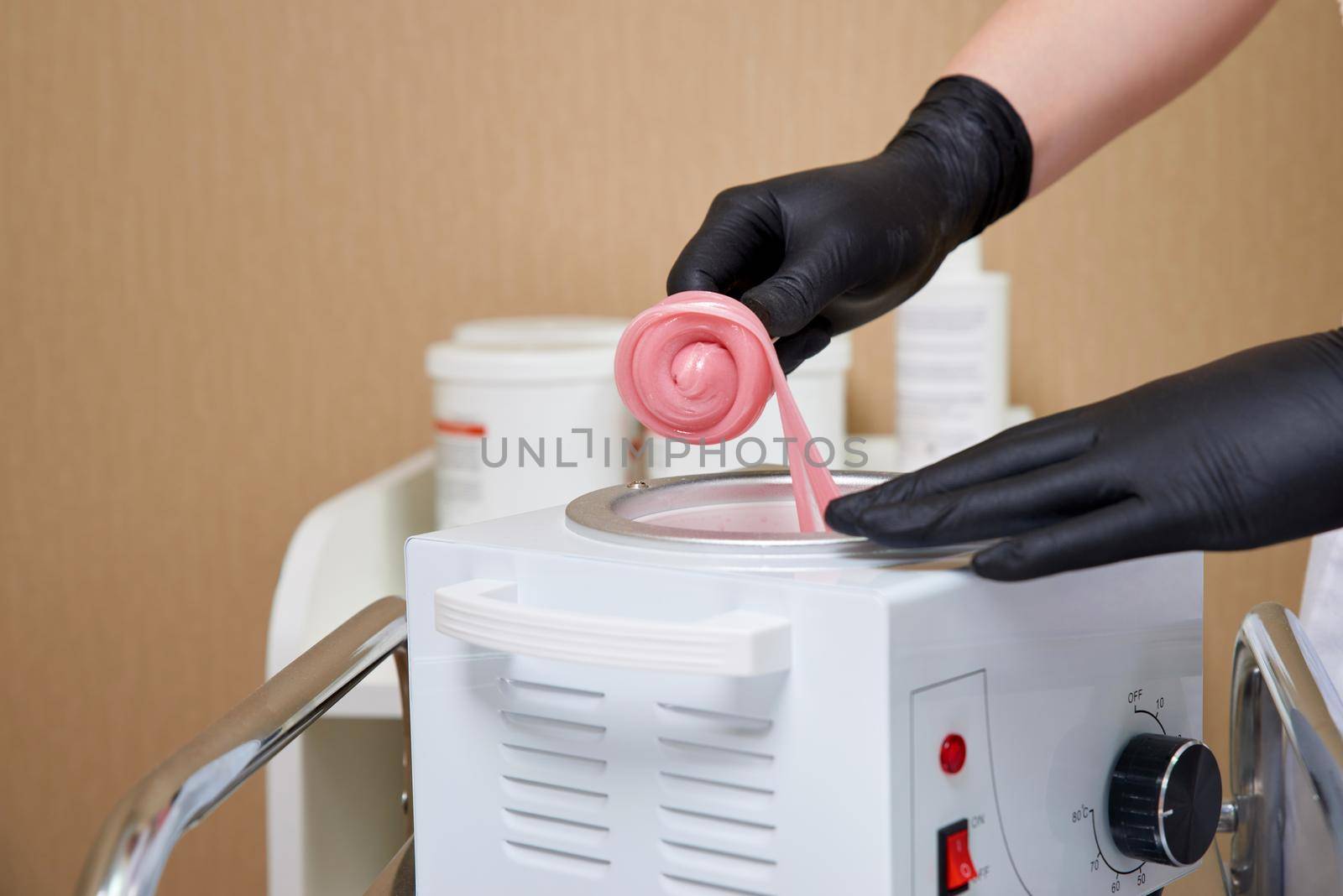 Wax for hair removal. Molten wax in a special container for heating the wax. preparing a warm Golden brow wax for hair removal.