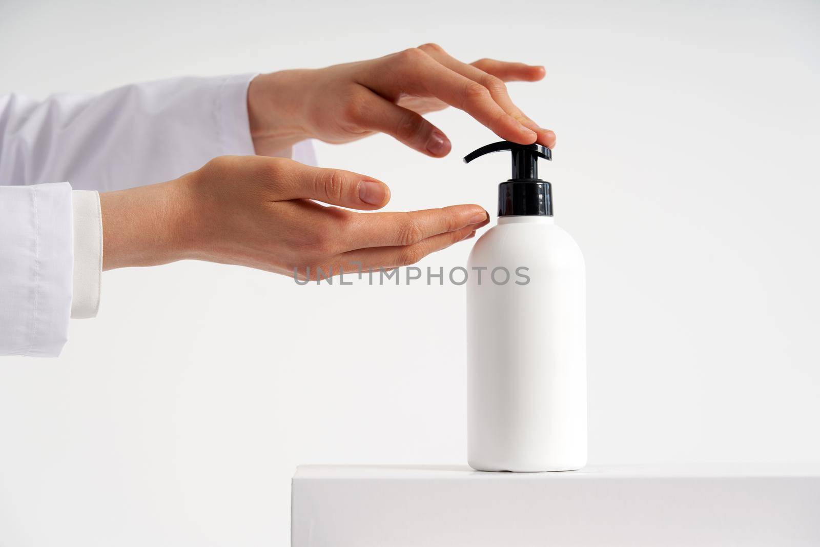 Woman hands pushing pump plastic soap bottle