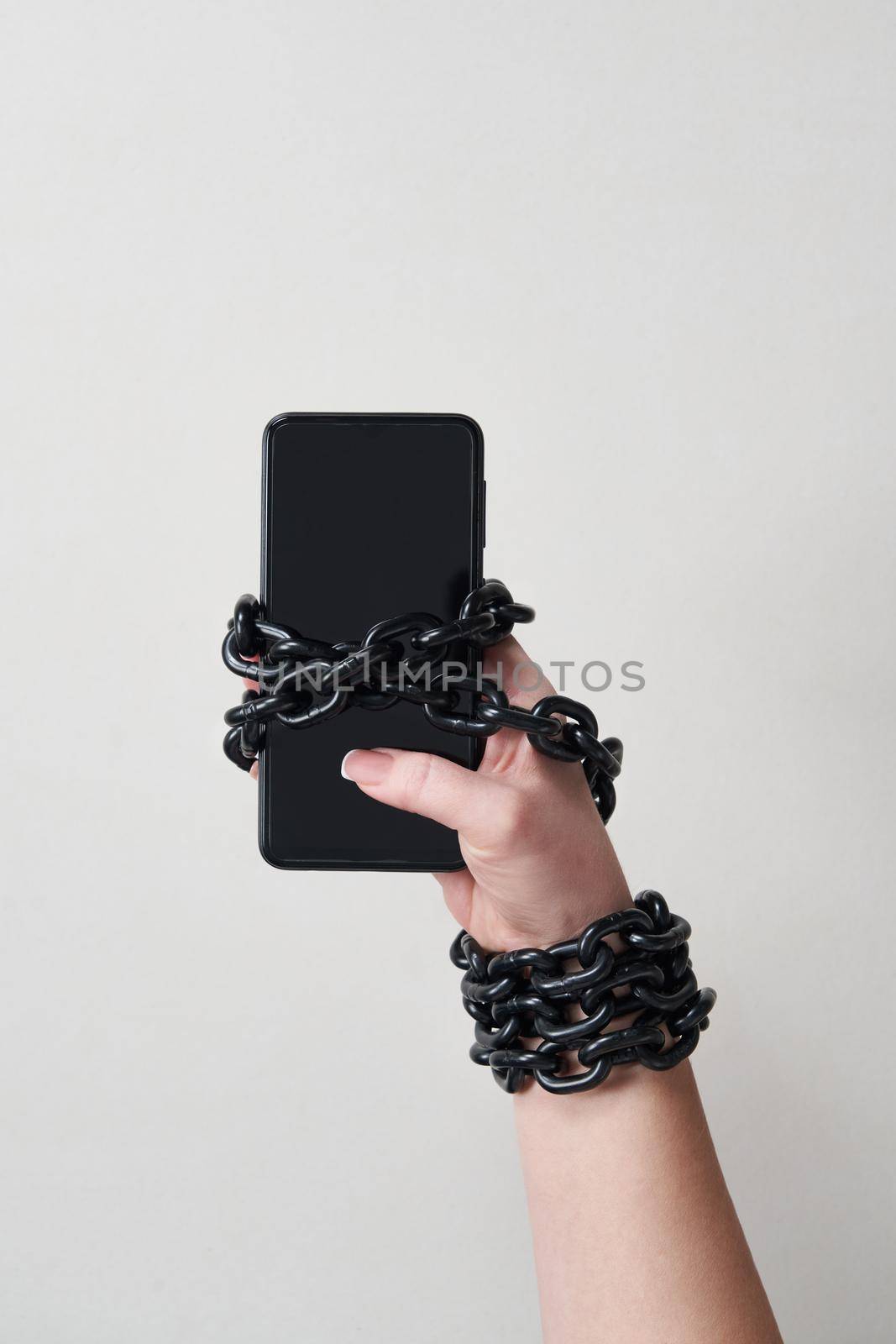 Close-Up Of Person Holding Mobile Phone And Chain