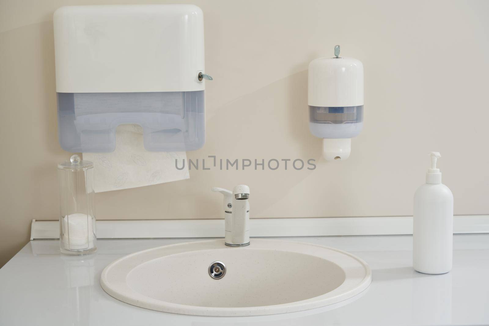 Faucet and liquid soap bottle on a sink background. High quality photo